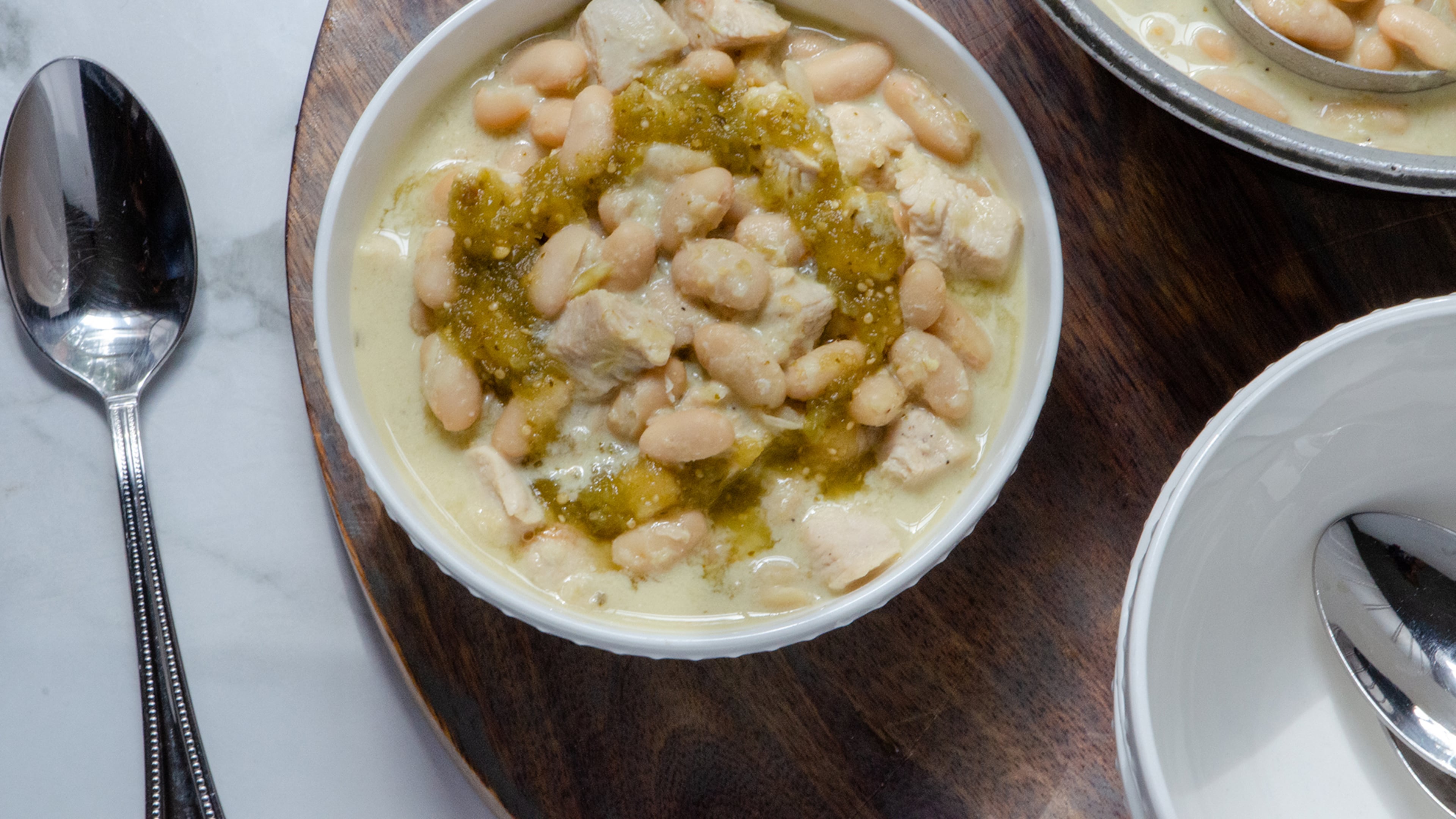 A hearty bowl of white chicken chili made with chicken breast, chicken stock, white beans, salsa verde and Neufchatel cheese. (Styling by Lori Horne / Virginia Willis for The Atlanta Journal-Constitution)