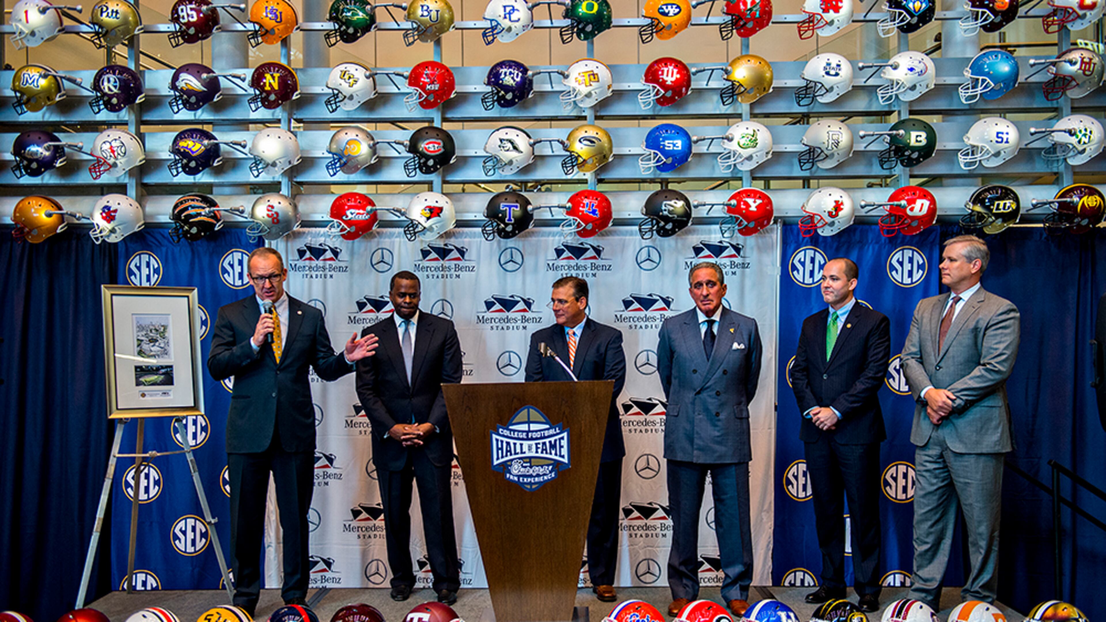 SEC Commissioner Greg Sankey (left) answers questions Tuesday during the press conference announcing a 10-year deal at the College Football Hall of Fame in Atlanta to play the SEC Championship game at Mercedes-Benz Stadium. Sankey was joined on stage with Atlanta Mayor Kasim Reed (second from left), Atlanta Falcons owner Arthur Blank (third right) and other officials.