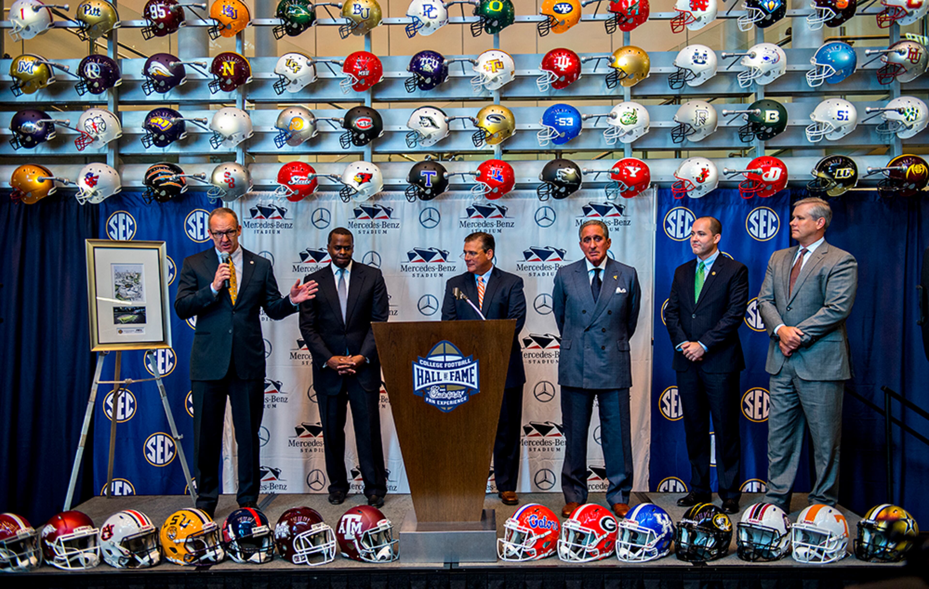 SEC Commissioner Greg Sankey (left) answers questions Tuesday during the press conference announcing a 10-year deal at the College Football Hall of Fame in Atlanta to play the SEC Championship game at Mercedes-Benz Stadium. Sankey was joined on stage with Atlanta Mayor Kasim Reed (second from left), Atlanta Falcons owner Arthur Blank (third right) and other officials.