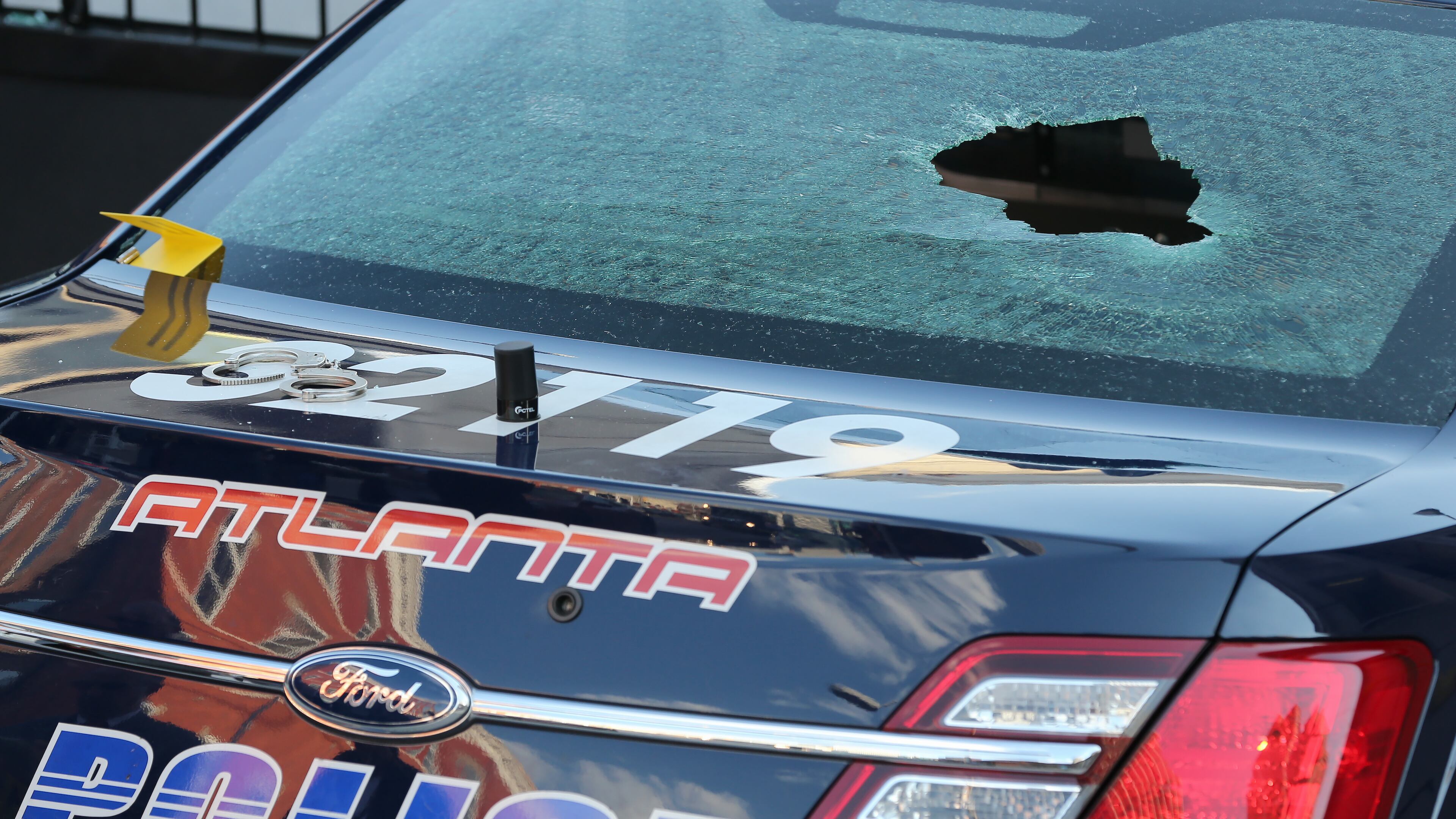 An Atlanta police car with broken windows and a bullet hole in the windshield sits on Pryor Street in downtown Atlanta where police say a woman who was in custody began shooting at officers from the back seat of the patrol car Thursday evening April 30, 2015. The suspect, who police say they found in a stolen car, died after being transported to the hospital. Ben Gray / bgray@ajc.com