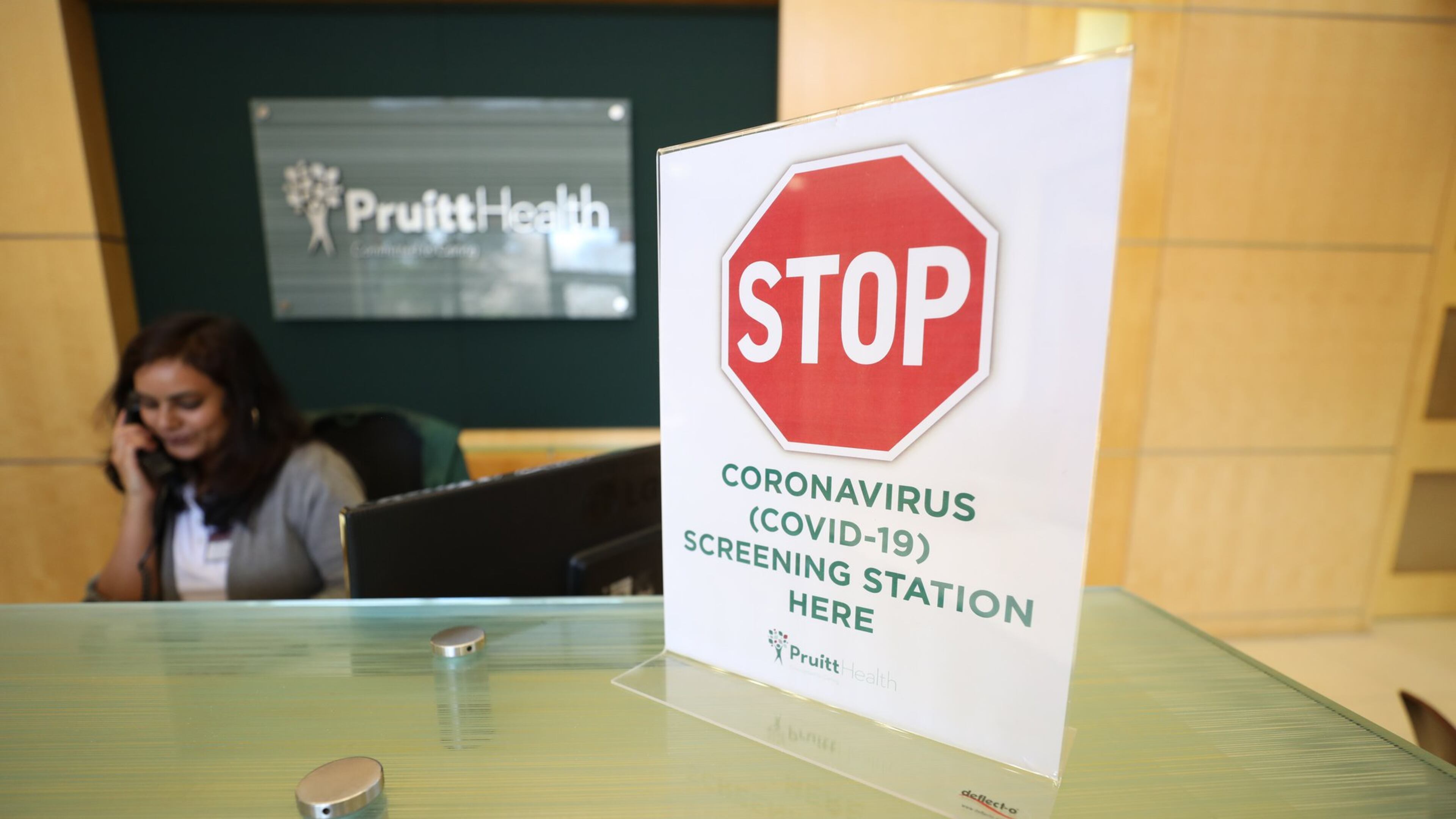 A warning sign for coronavirus screenings is displayed at the front desk at PruittHealth’s emergency call center. BRANDEN CAMP/SPECIAL