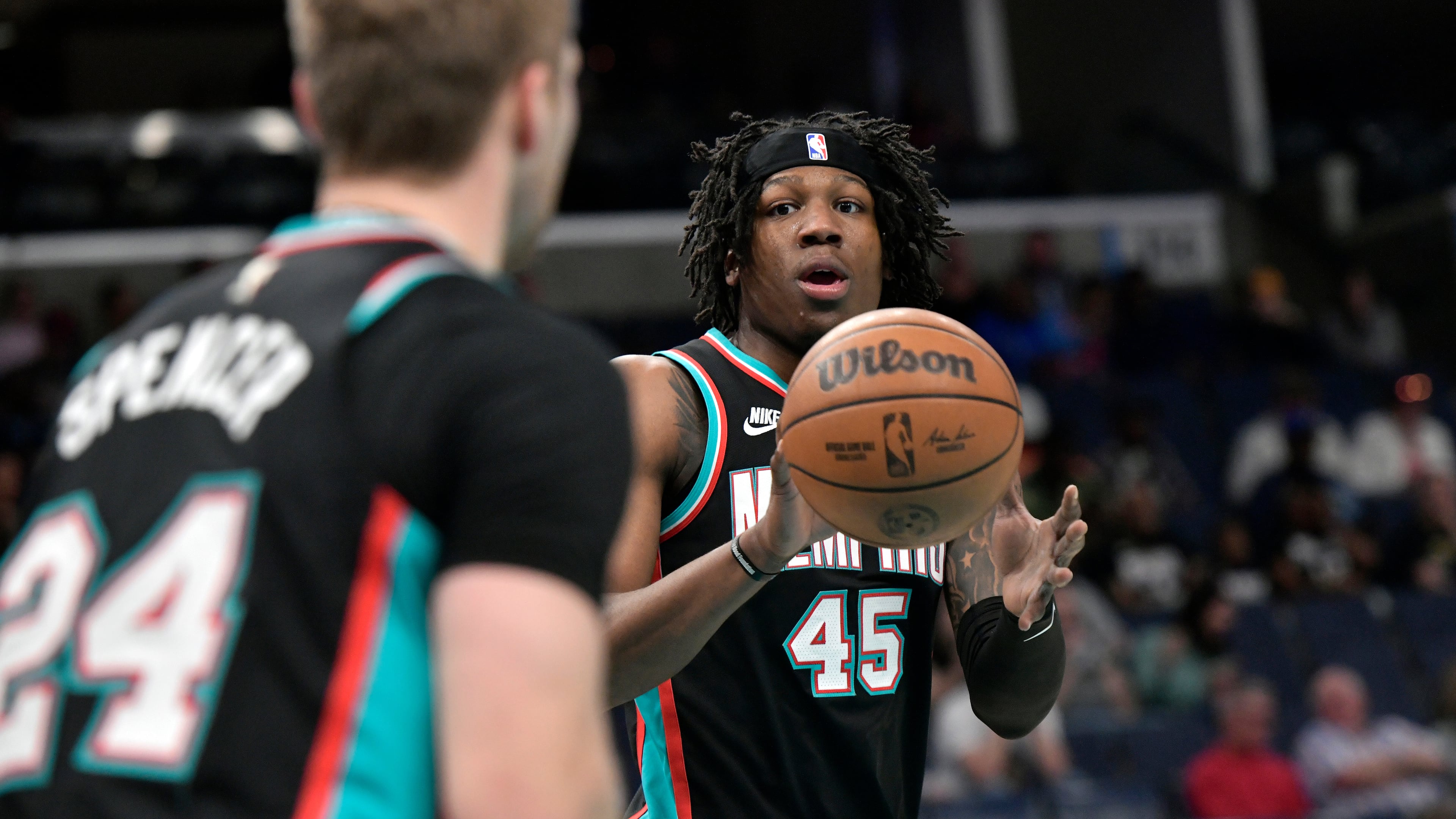 Memphis Grizzlies guard Cam Spencer (24) passes to forward GG Jackson II (45) in the first half of an NBA basketball game against the Cleveland Cavaliers, Monday, April 6, 2026, in Memphis, Tenn. (AP Photo/Brandon Dill)