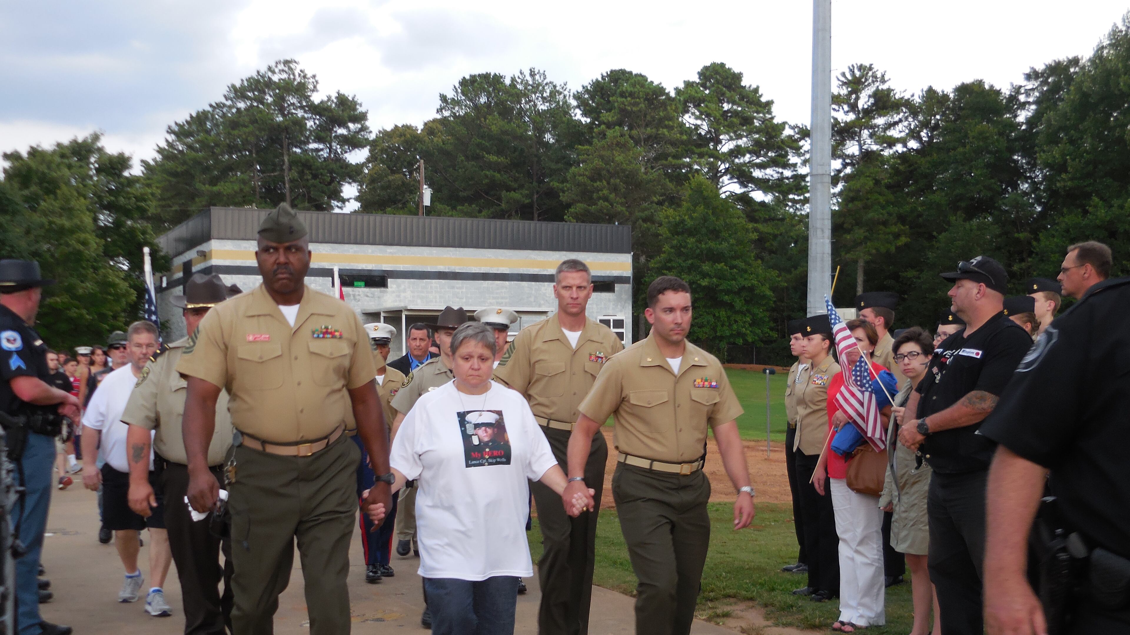 USMC Lance Cpl. Skip Wells' mother Cathy Wells is escorted into the stadium. Photo: Jennifer Brett
