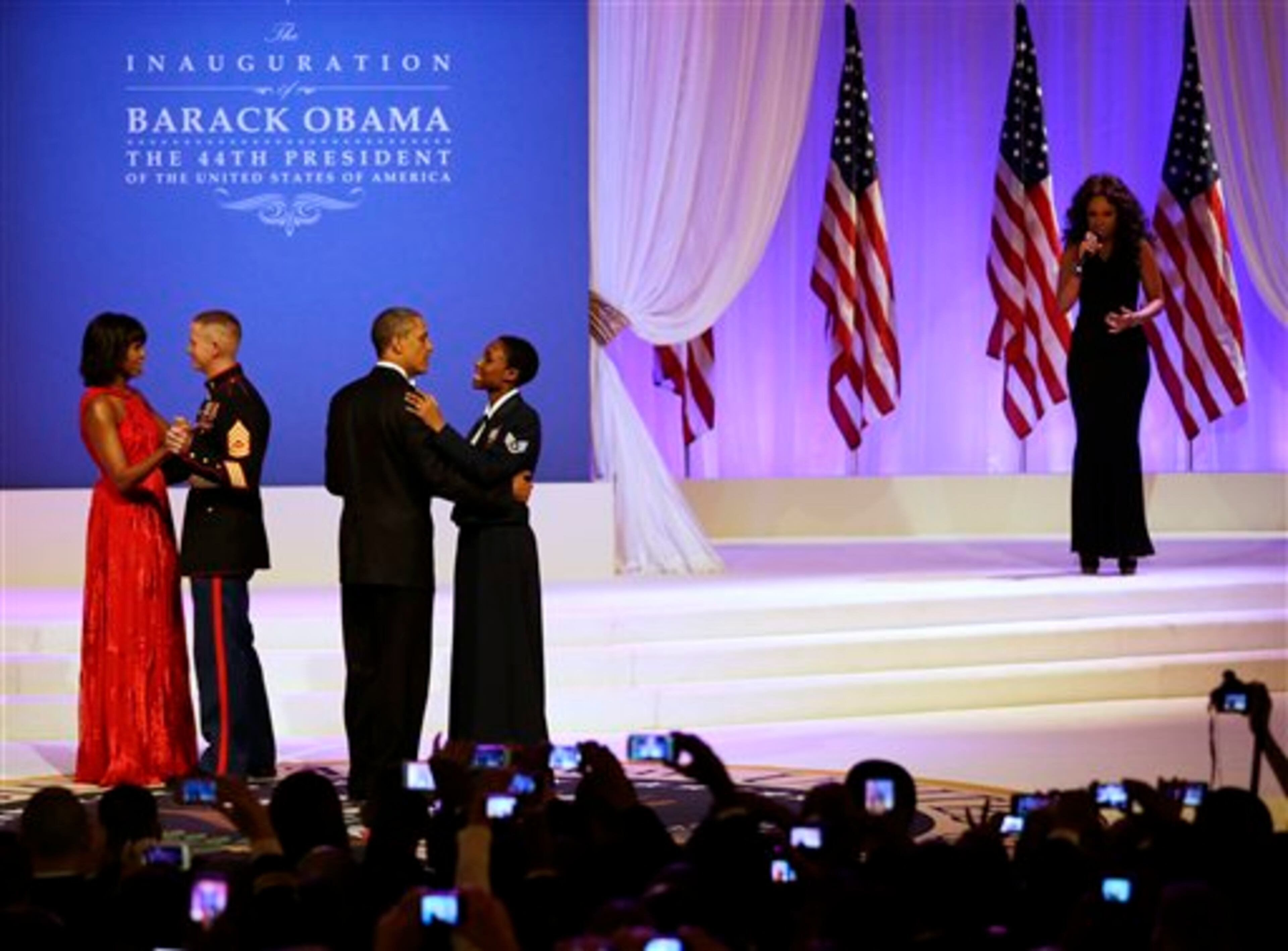 Jennifer Hudson performs while President Barack Obama dances with Air Force Staff Sgt. Bria Nelson as first lady Michelle Obama dances with Marine Corps Gunnery Sgt. Timother Easterling at the Commander-in-Chief's Inaugural Ball in Washington, at the Washington Convention Center during the 57th Presidential Inauguration Monday, Jan. 21, 2013. (AP Photo/Jacquelyn Martin)