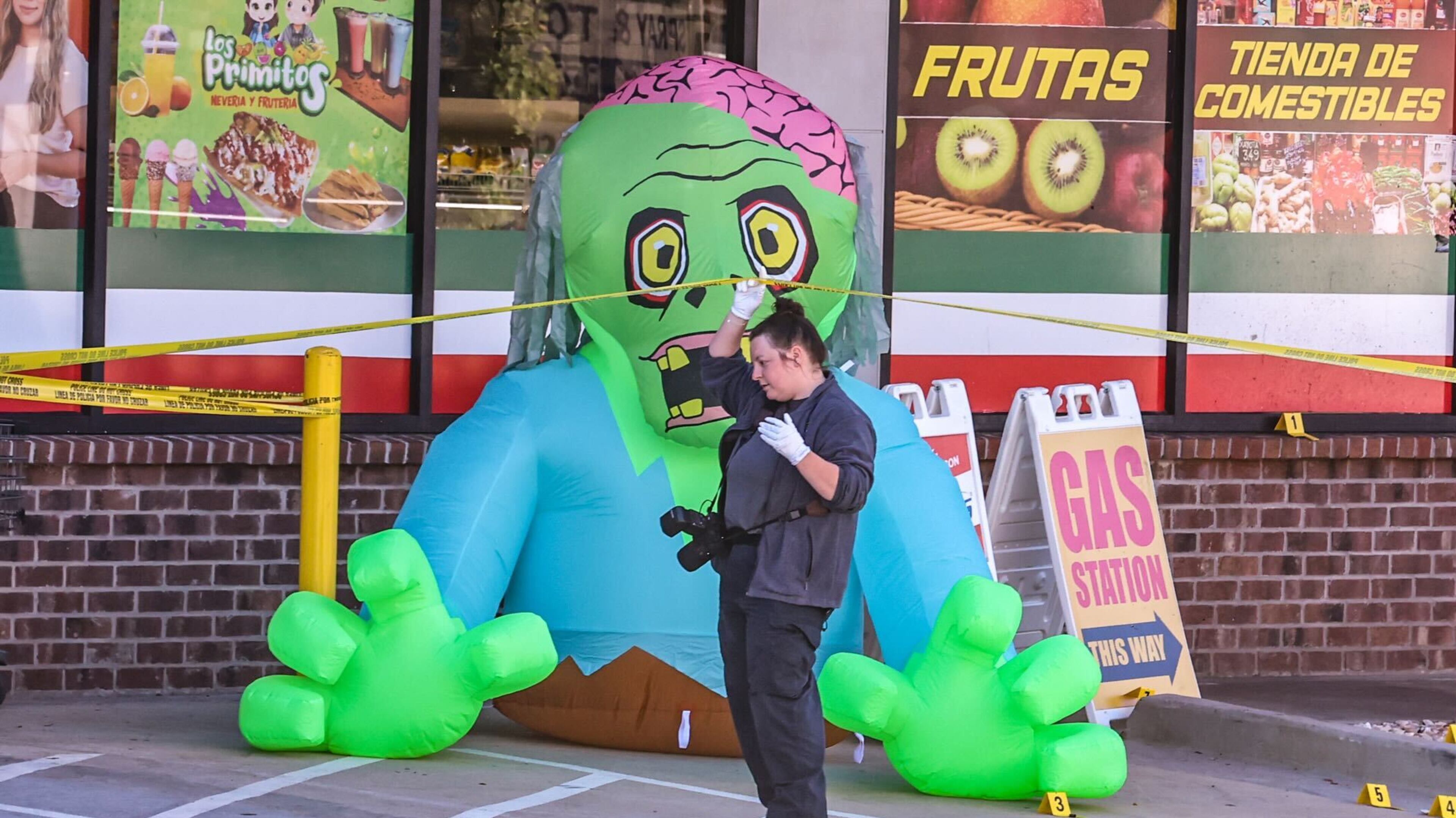 Gwinnett County police investigate a shooting outside Supermercado Mexicano on Jimmy Carter Boulevard, which is decorated for Halloween.