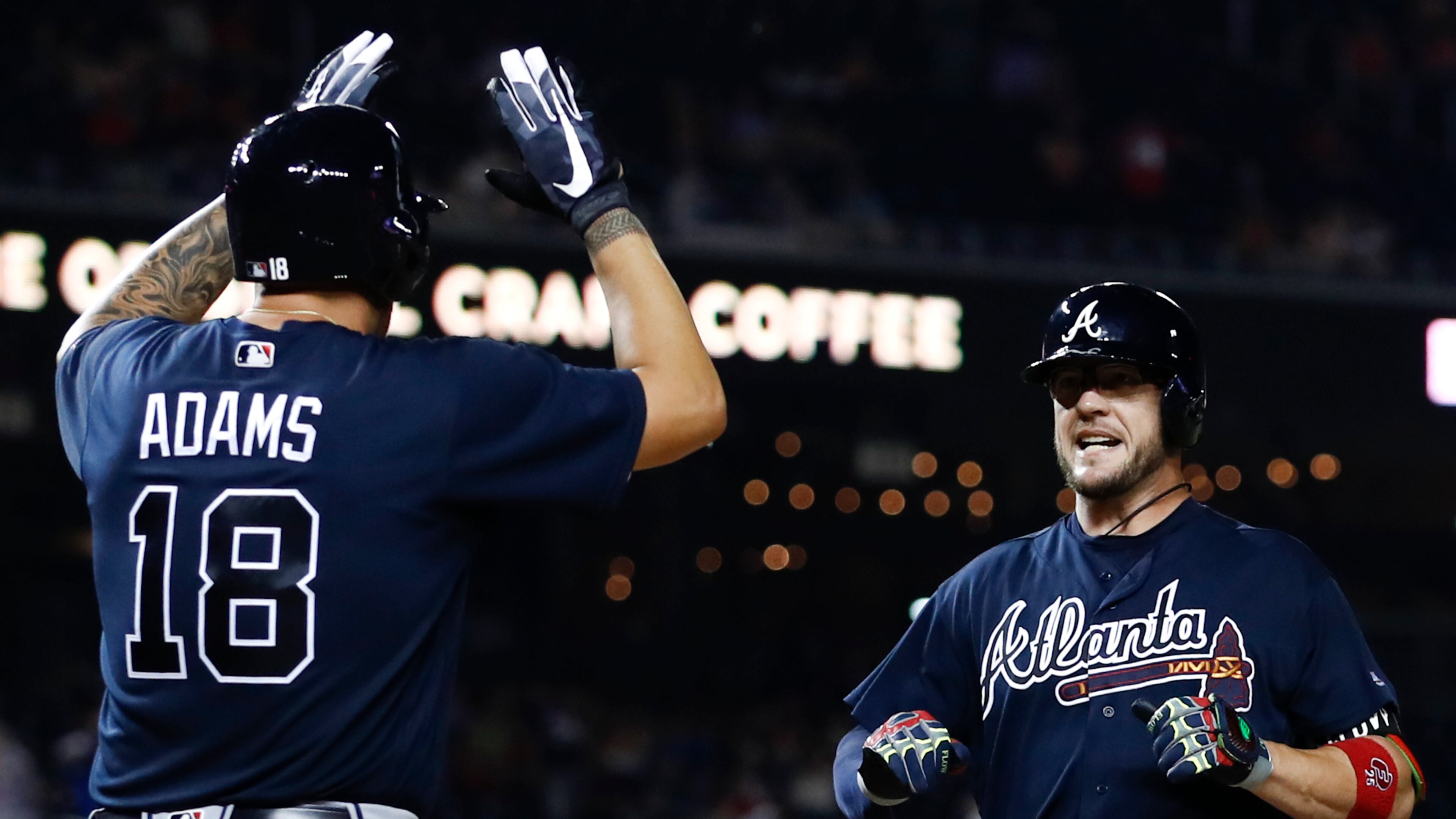 Braves catcher Tyler Flowers is welcomed to his other home — home plate — by Matt Adams (18) after his ninth-inning, three-run home run Monday that beat the Washington Nationals. (AP Photo/Carolyn Kaster)