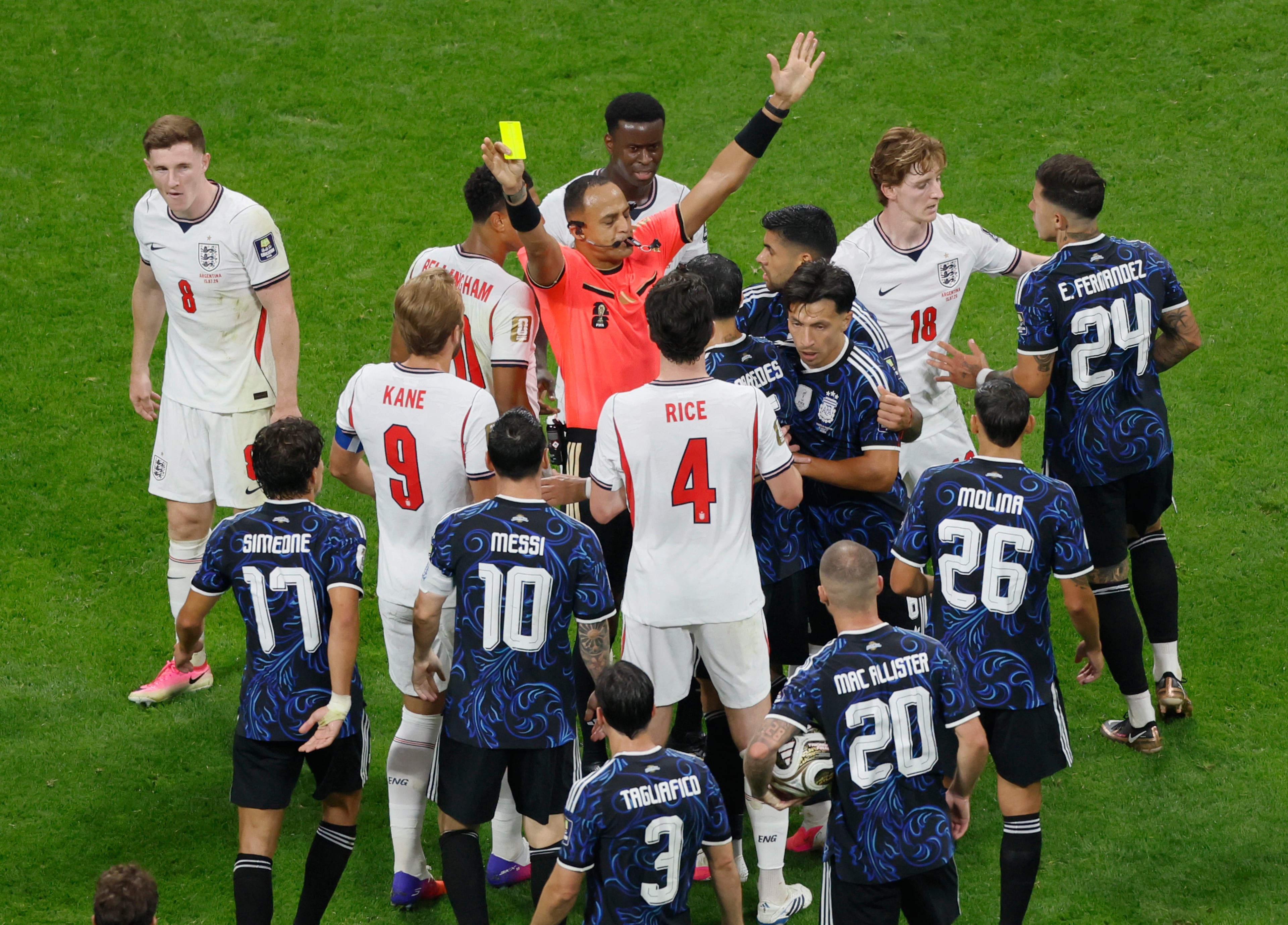 Referee Ismail Elfath awards a yellow card to England's Elliot Anderson, upper left, for a foul on Argentina's Lionel Messi during first half of Argentina vs. England FIFA World Cup Semifinal match at Atlanta Stadium (Mercedes-Benz Stadium) on Wednesday, July 15, 2026. (Miguel Martinez/AJC)