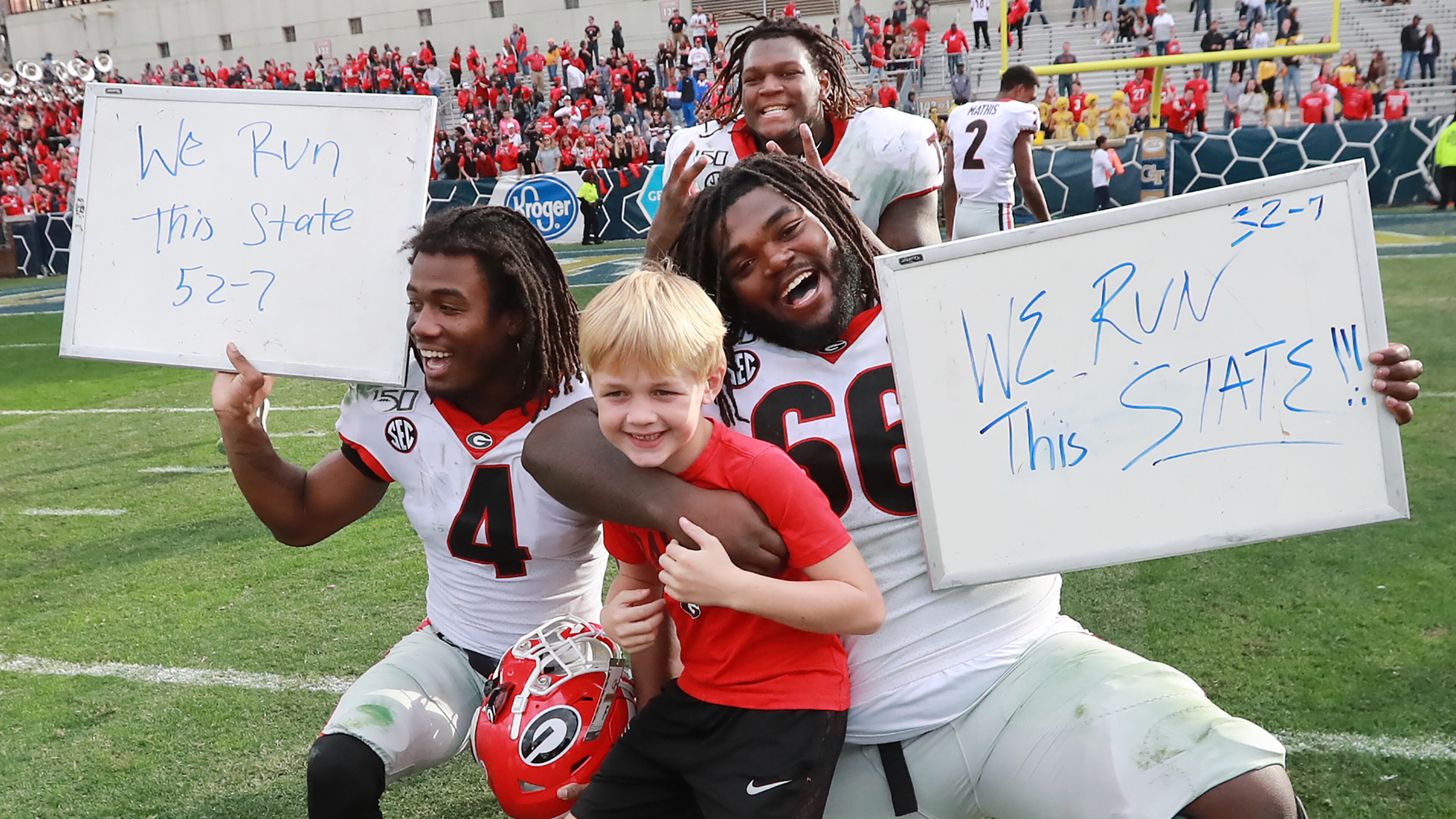 Georgia players James Cook ( left), Isaiah Wilson (top) and Solomon Kindley (right) celebrate a 52-7 victory over Georgia Tech with head coach Kirby Smart's son Andrew in a NCAA college football game on Saturday, November 30, 2019, in Atlanta. Curtis Compton/ccompton@ajc.com