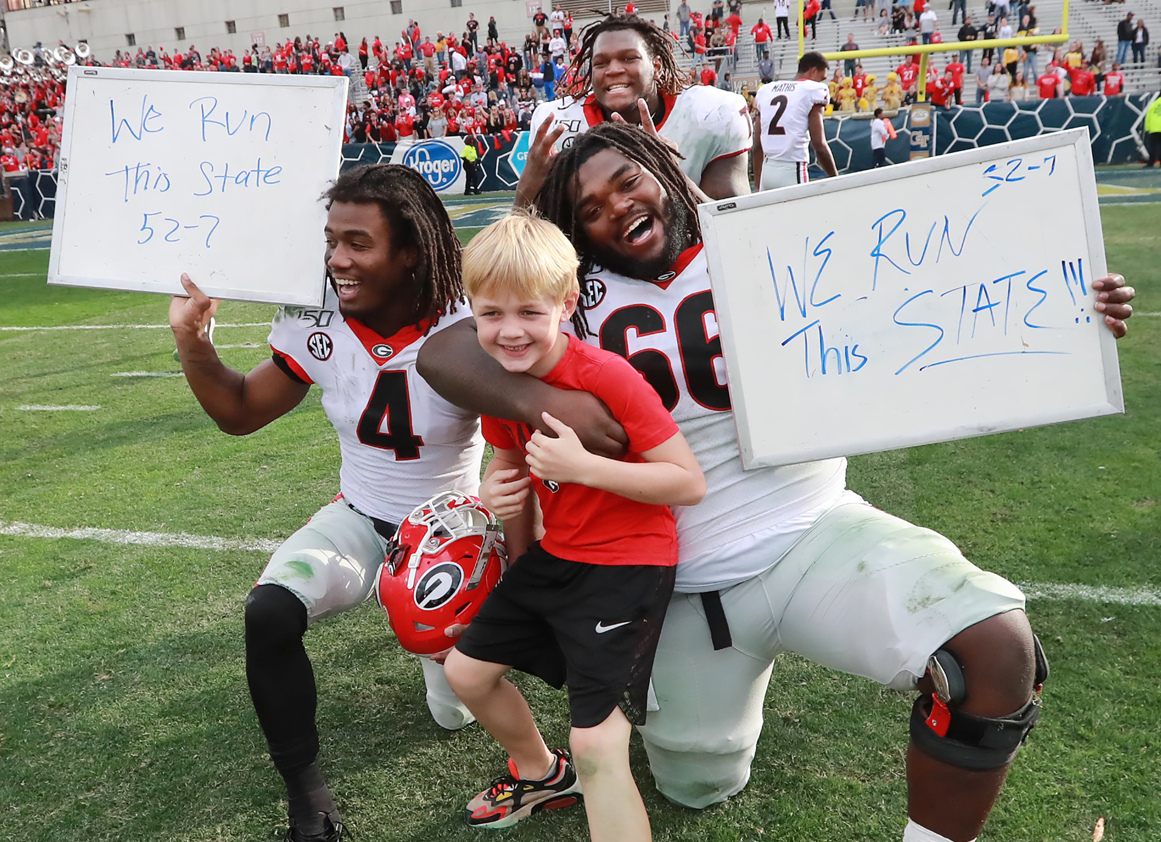 Georgia players James Cook ( left), Isaiah Wilson (top) and Solomon Kindley (right) celebrate a 52-7 victory over Georgia Tech with head coach Kirby Smart's son Andrew in a NCAA college football game on Saturday, November 30, 2019, in Atlanta. Curtis Compton/ccompton@ajc.com