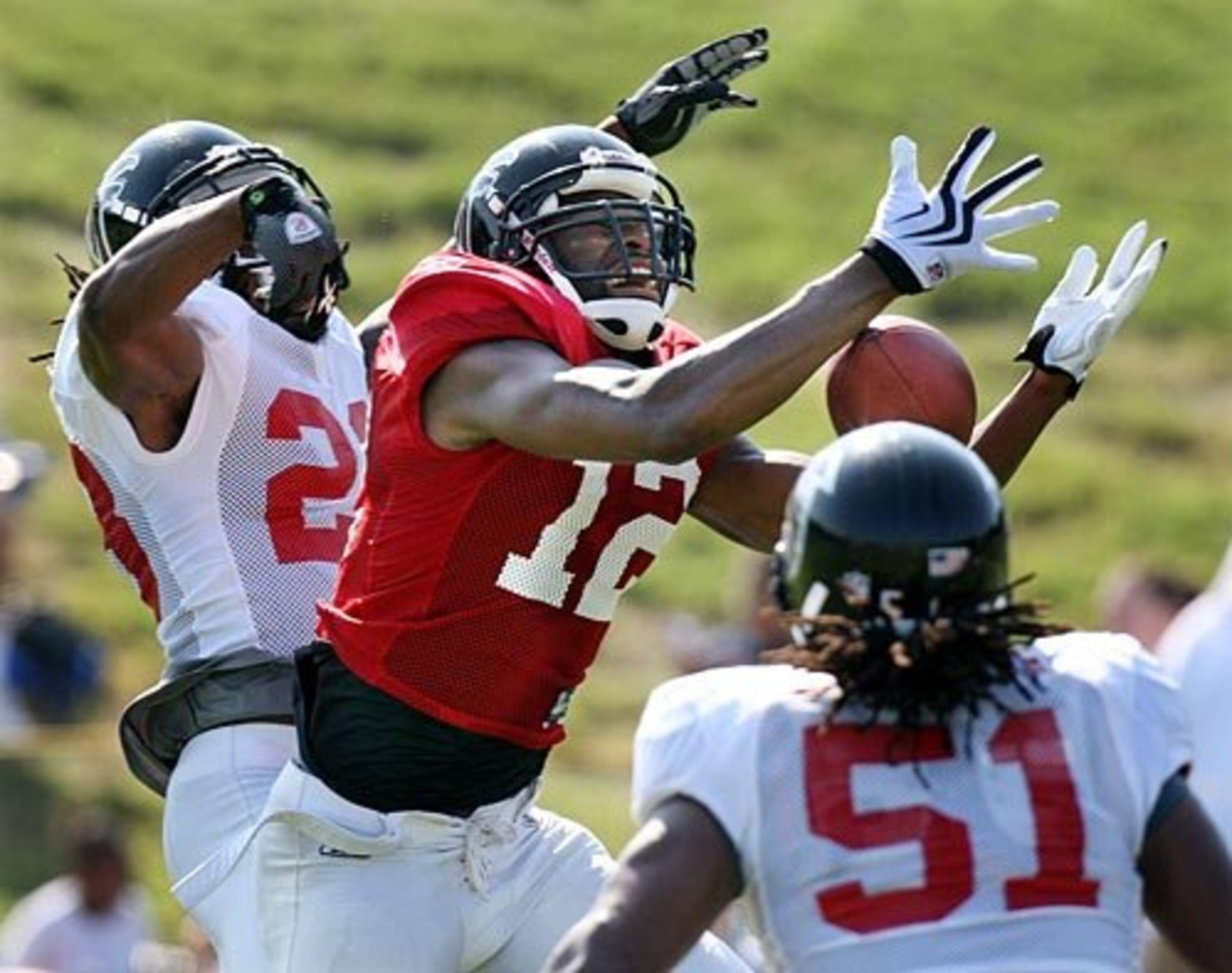 Wide receiver Michael Jenkins (12) is double teamed by safety Thomas DeCoud (28, left) and linebacker Tony Gilbert (51) .