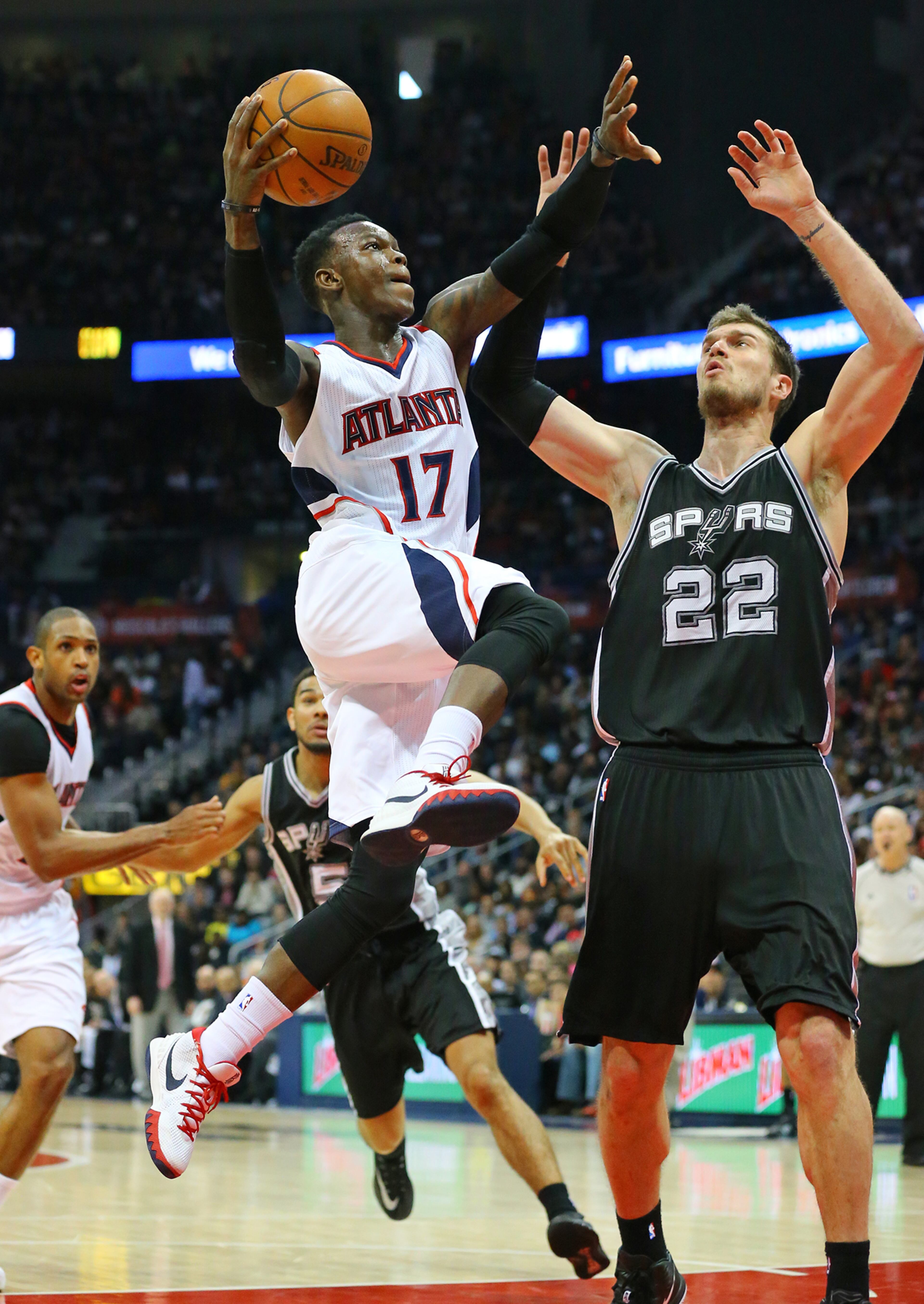 Hawks guard Dennis Schroder takes it to the basket for two points past Spurs forward Tiago Splitter on Sunday, March 22, 2015 in Atlanta. Curtis Compton / ccompton@ajc.com