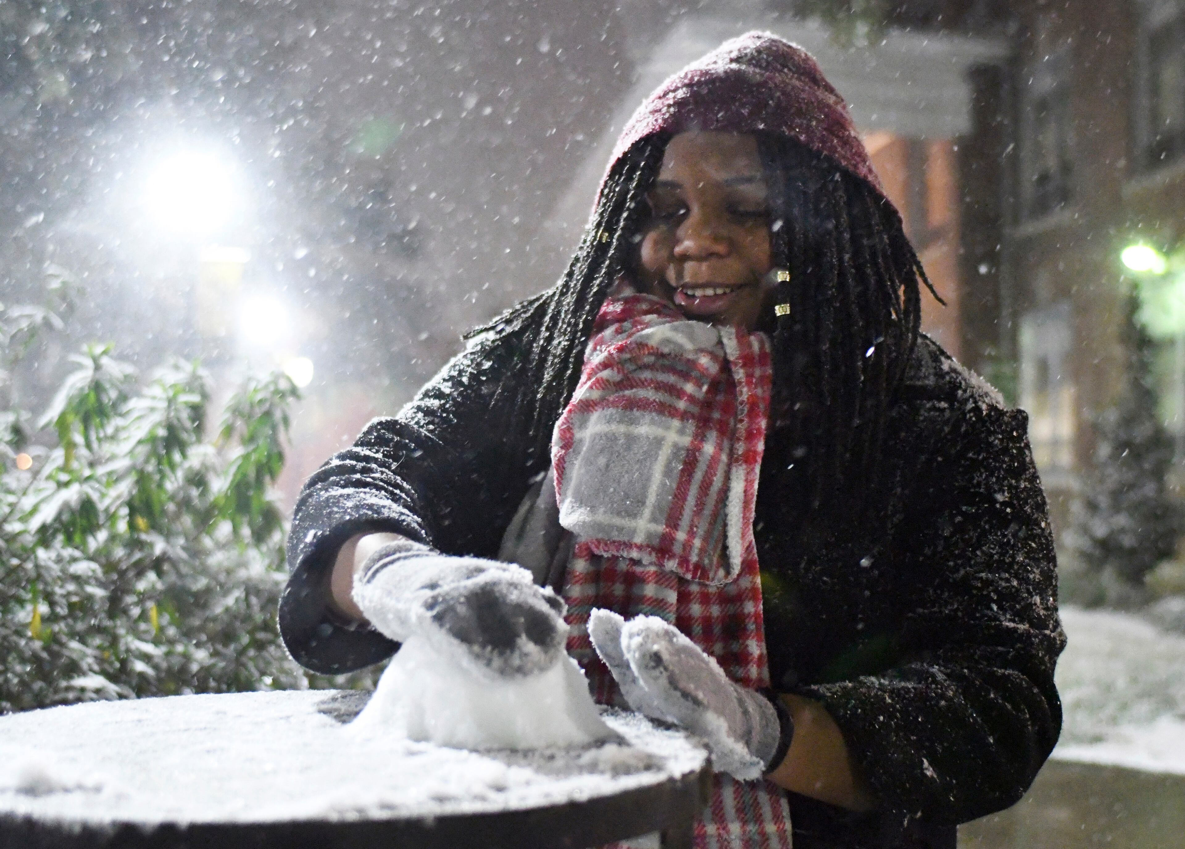 Southern Miss junior Maya Caradine makes a snowball to throw at her friends as severe winter weather comes to Hattiesburg, Miss., Tuesday, Jan. 16, 2018. A wintry mix of snow, sleet and freezing rain blanketed a large swath of the South, trailed by a blast of frigid air that could approach record low temperatures Wednesday.(Susan Broadbridge/Hattiesburg American via AP)