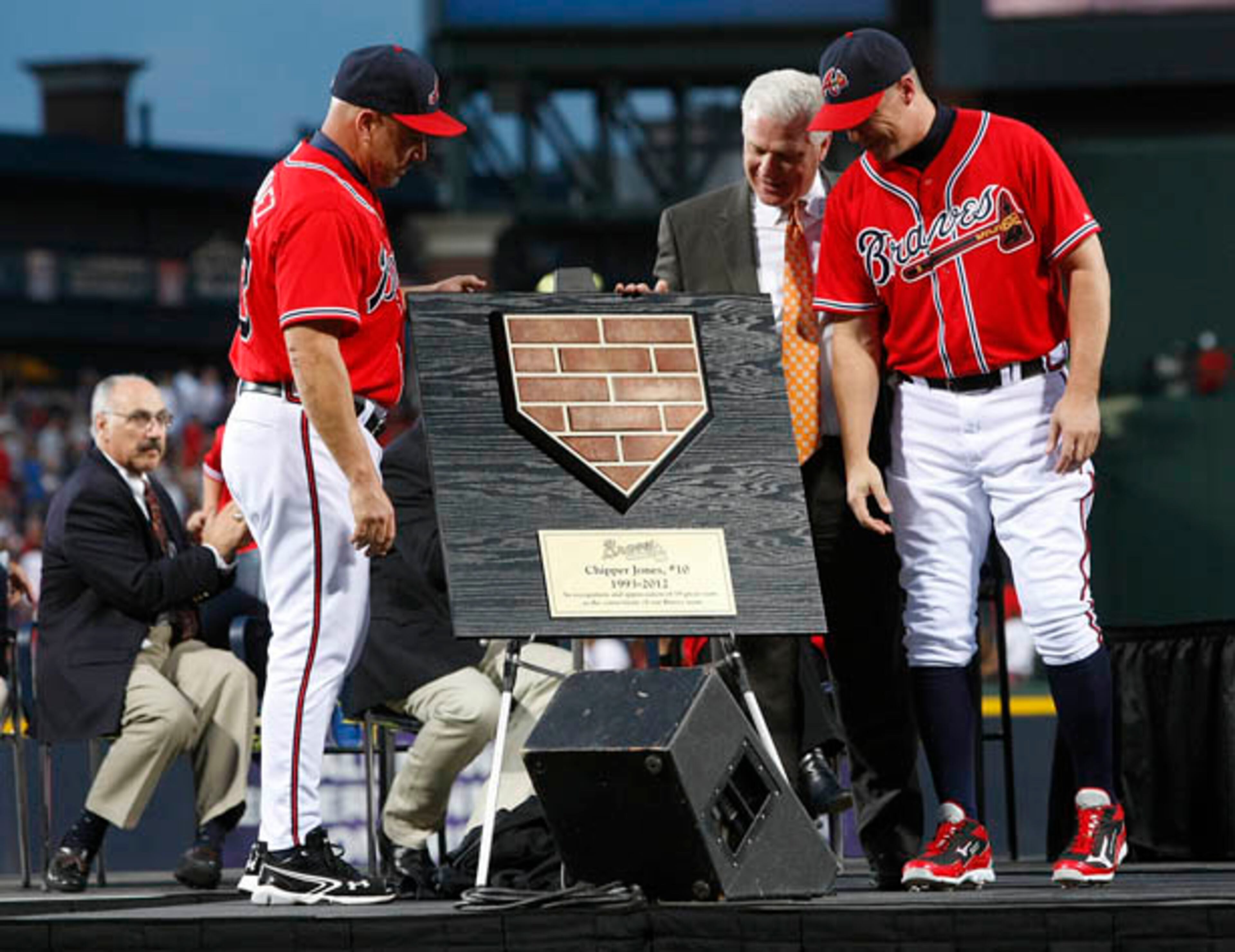 Braves manager Fredi Gonzalez (from left) and general manager Frank Wren present Chipper Jones a homeplate - made from bricks from Tuner Field to symbolize Jones as a foundation of the team.