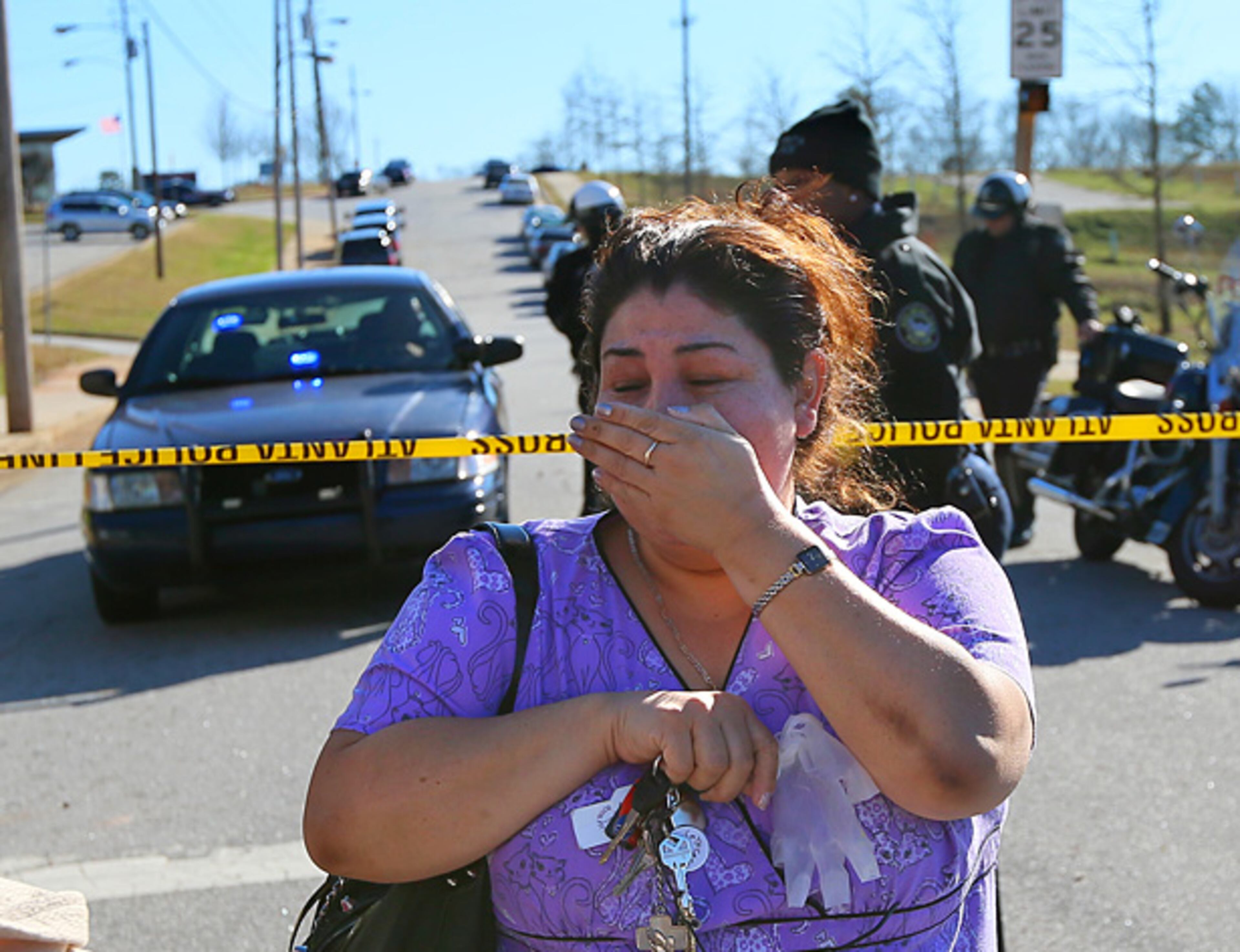 A distraught woman is turned back by police.