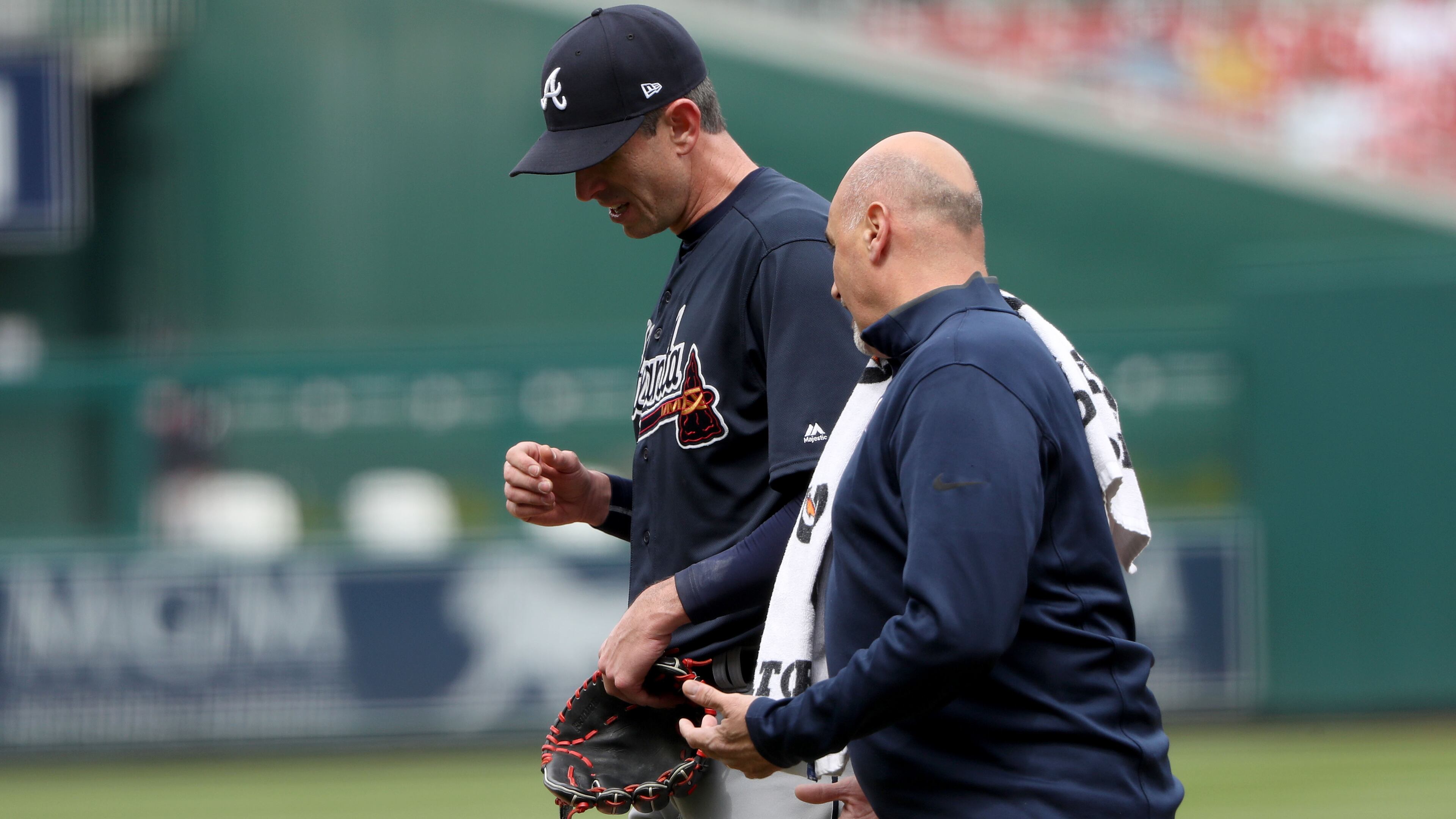 Braves pitcher Brandon McCarthy walks off the field with head trainer George Poulis after partially dislocating his non-throwing shoulder in the fifth inning Wednesday at Washington (Photo by Rob Carr/Getty Images)