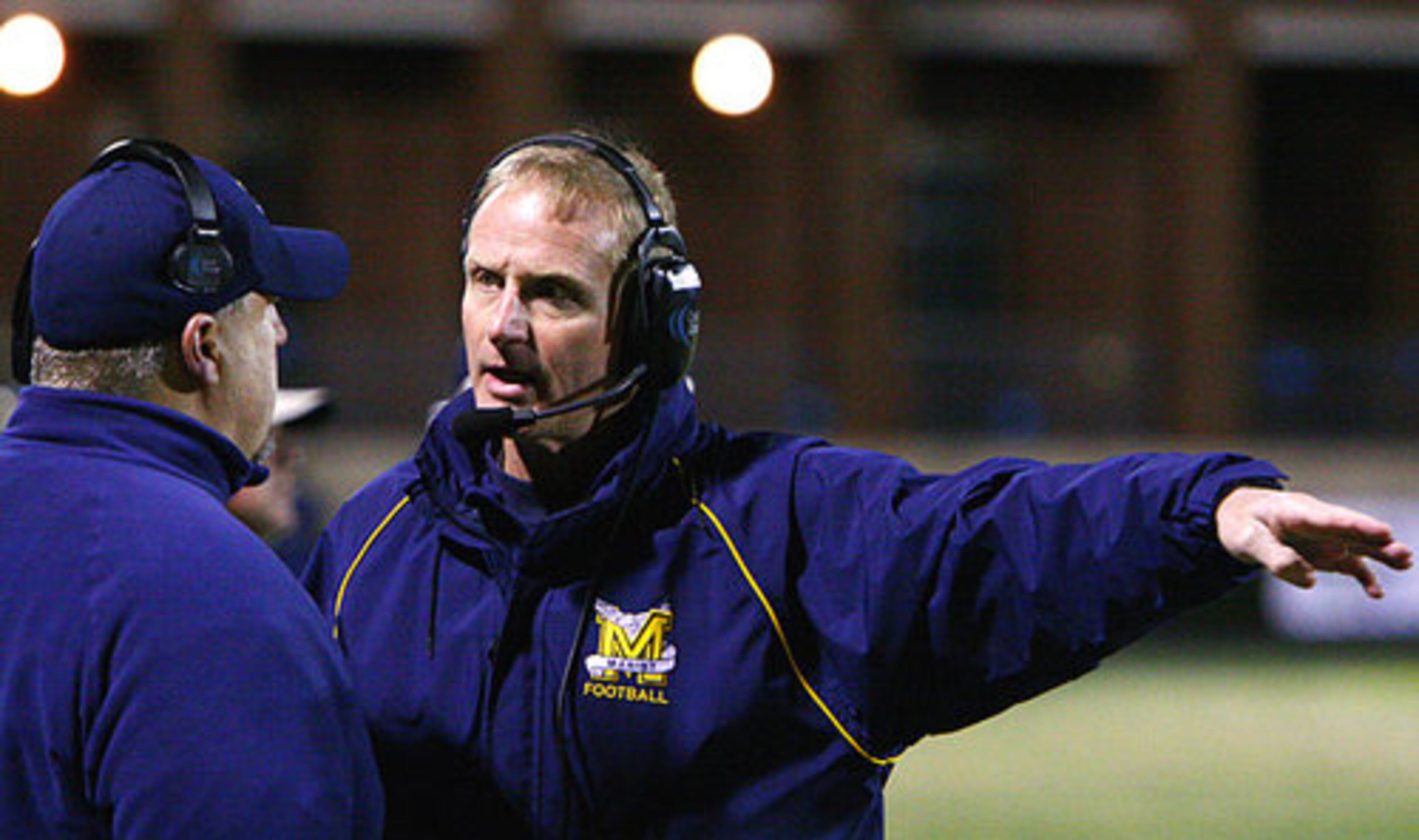 Marist head coach Alan Chadwick discusses plays with a fellow coach.