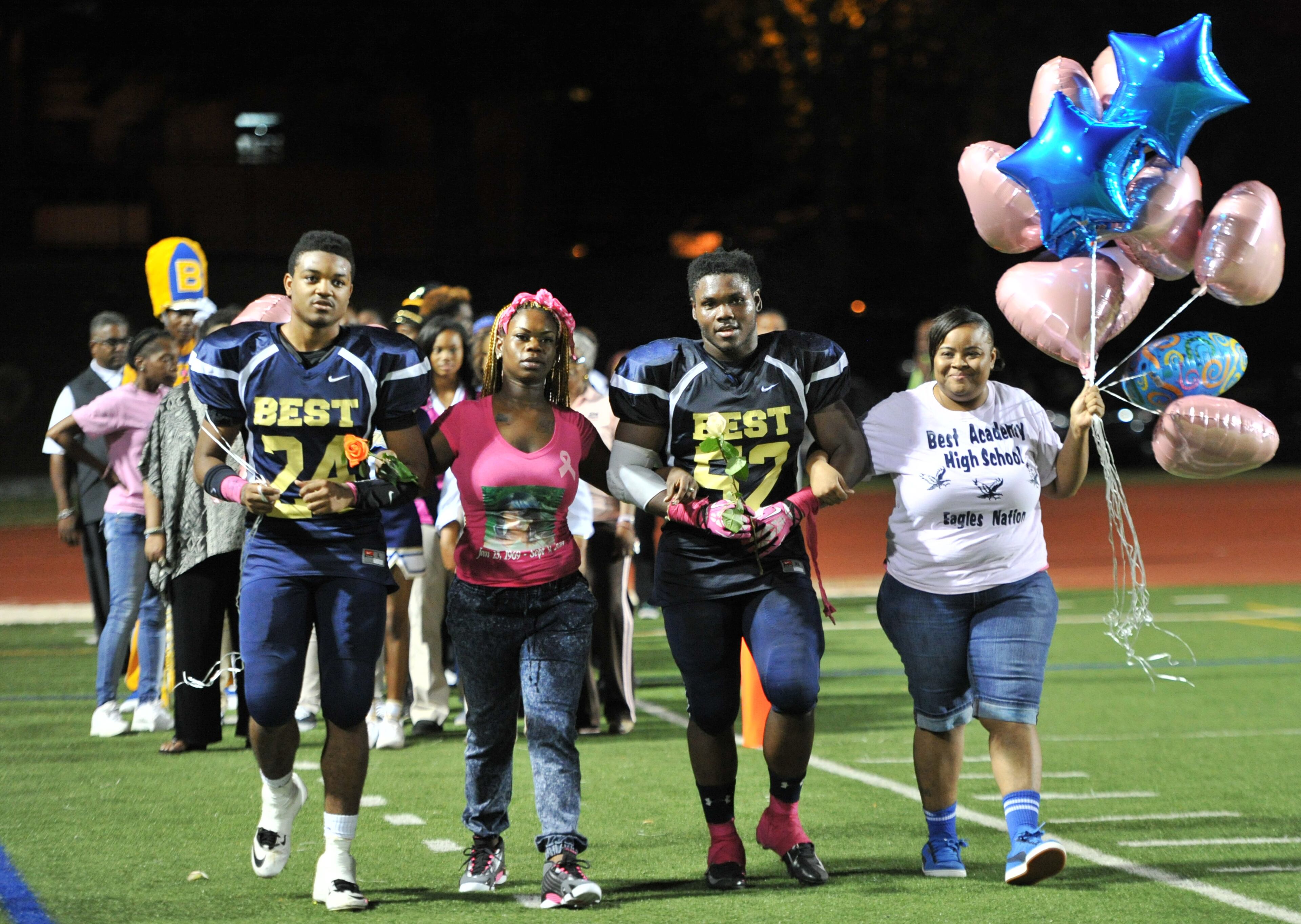 Ashley takes her mother’s place, accompanying her brother Darius Marshall, 18, onto the field on senior night. HYOSUB SHIN / HSHIN@AJC.COM