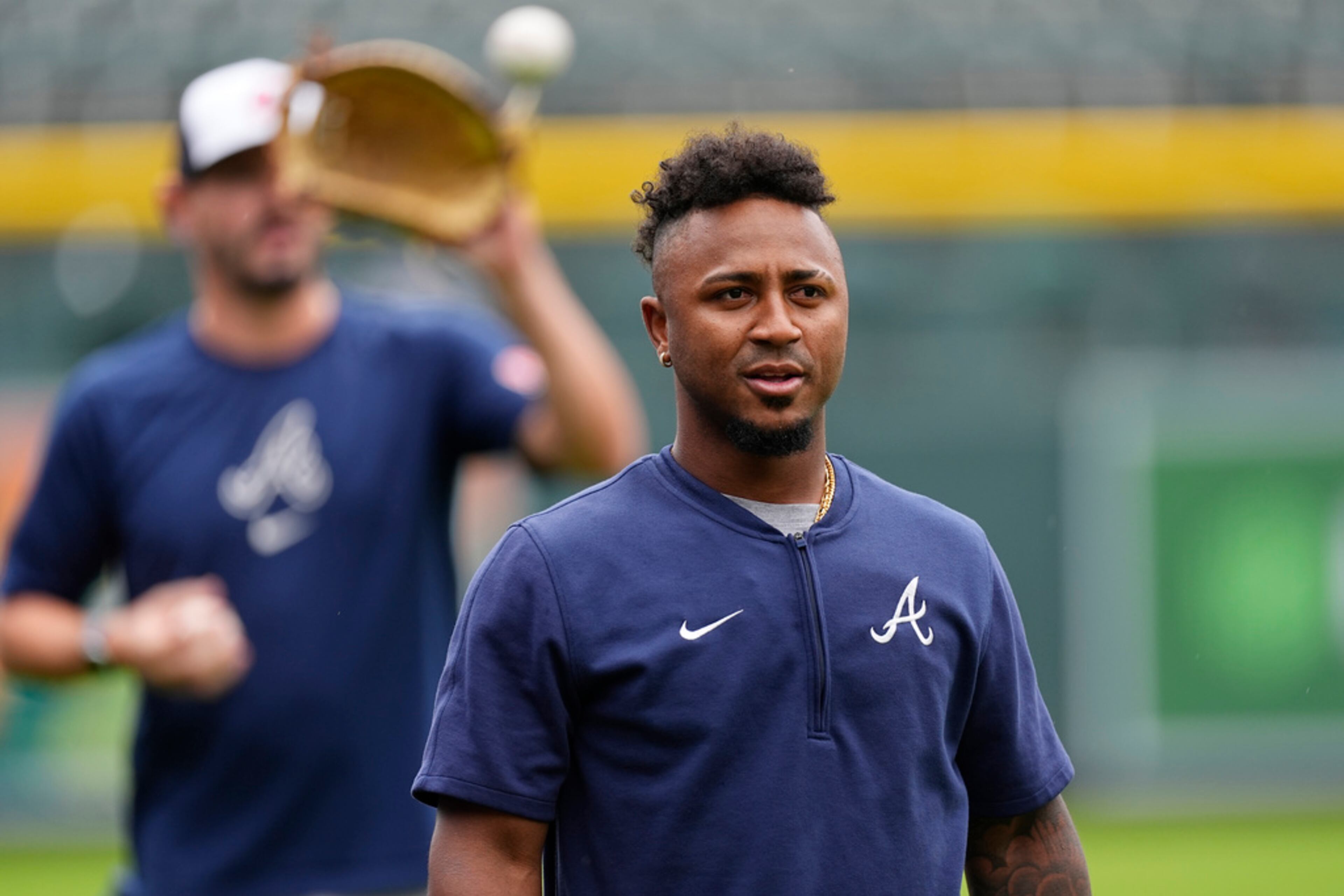 Injured Atlanta Braves second baseman Ozzie Albies heads back to the dugout after throwing before a baseball game against the Colorado Rockies, Friday, Aug. 9, 2024, in Denver. (AP Photo/David Zalubowski)