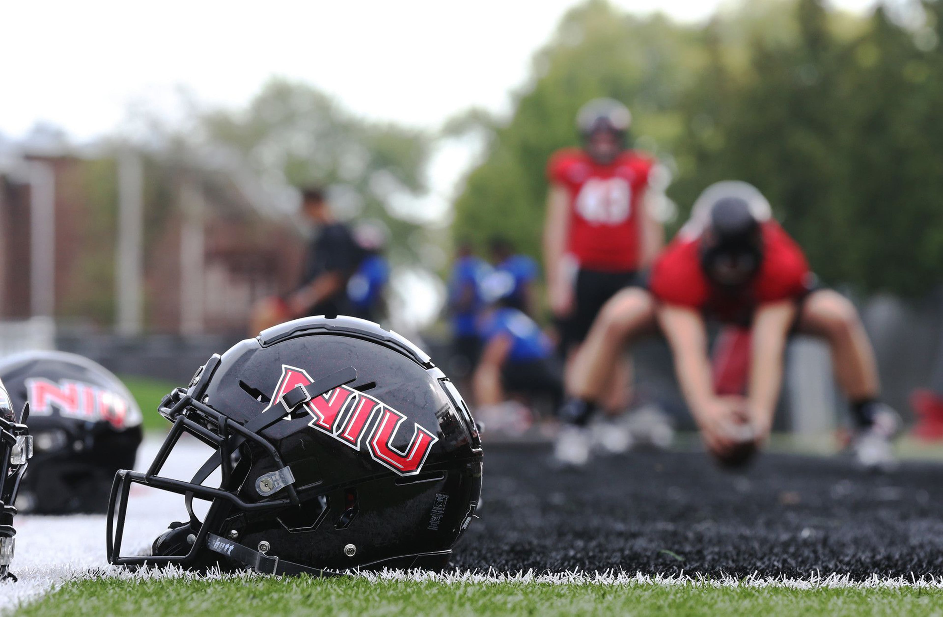 Helmets sit on the sideline as Northern Illinois University Huskies football players have a walk-through at Huskie Stadium in 2019 in DeKalb. (John J. Kim/Chicago Tribune/TNS)