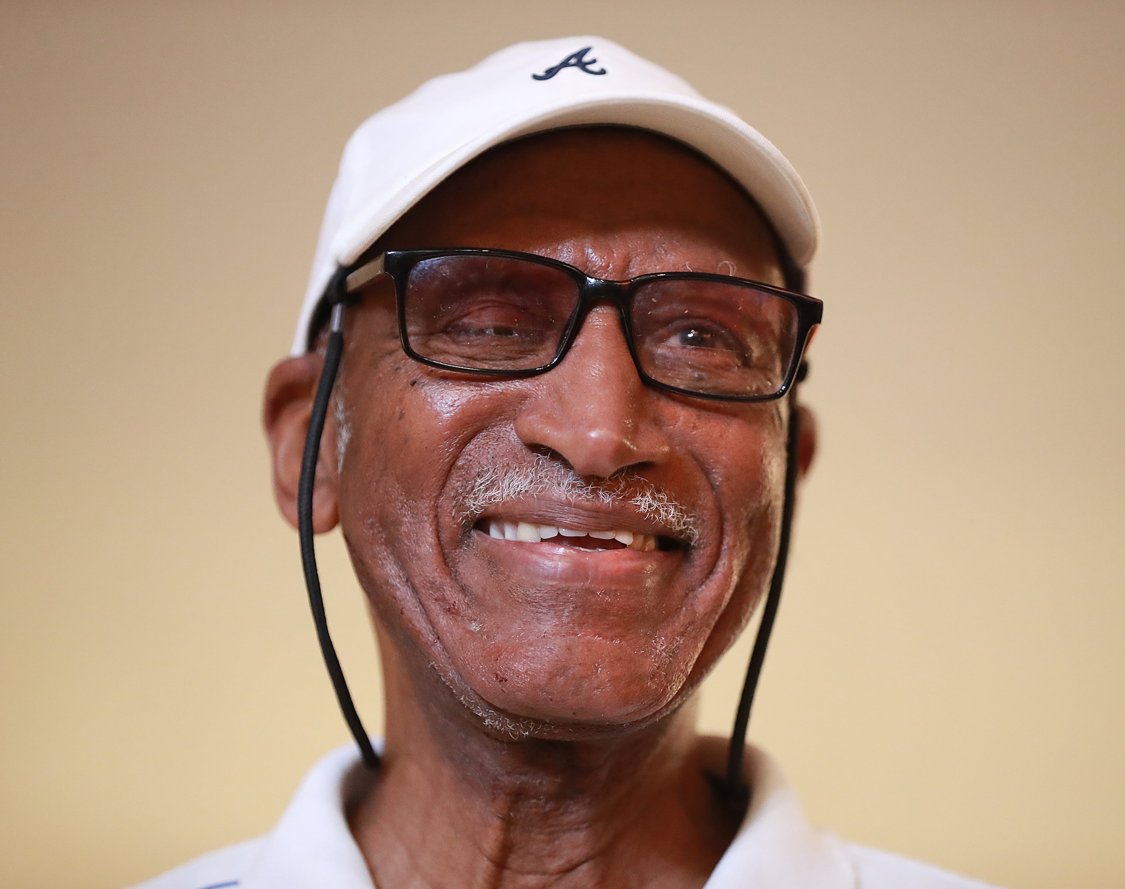 Walter Banks is all smiles as he arrives for his surprise 80th birthday celebration and the opening of a replica of his living room featuring his collection of Braves memorabilia at the SunTrust onUp Experience in The Battery Atlanta Monday. (Curtis Compton/ccompton@ajc.com)