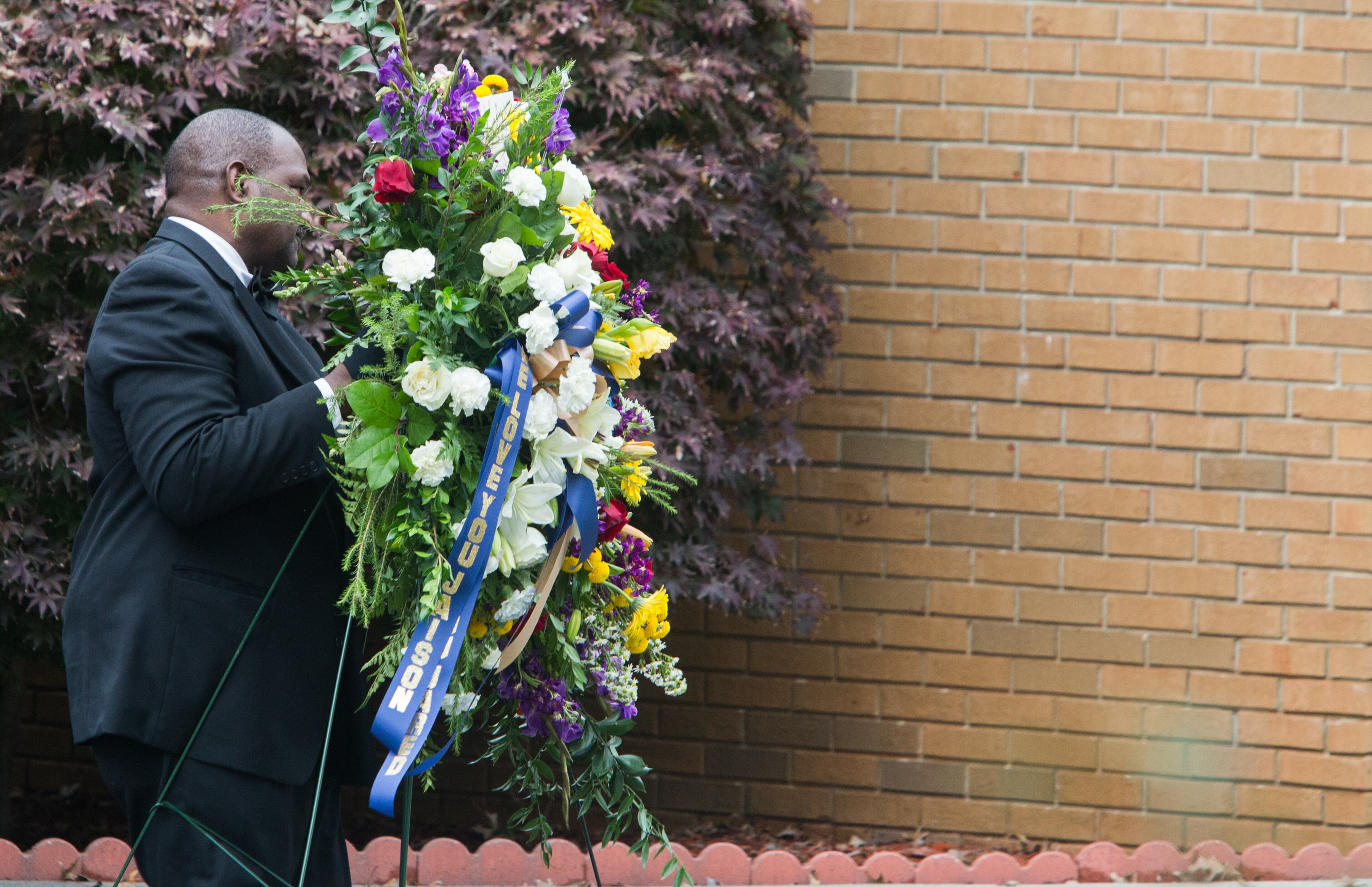 A funeral home worker carries flowers after a funeral service at Lawrenceville Church of God for 17-year-old Jared Brown and his 15-year-old brother Jaison Brown, Saturday, Nov. 7, 2015, in Lawrenceville, Ga. The two brothers were killed in a car accident last Friday morning on Ga. 316 less than two miles from Dacula High School where they attended. BRANDEN CAMP/SPECIAL