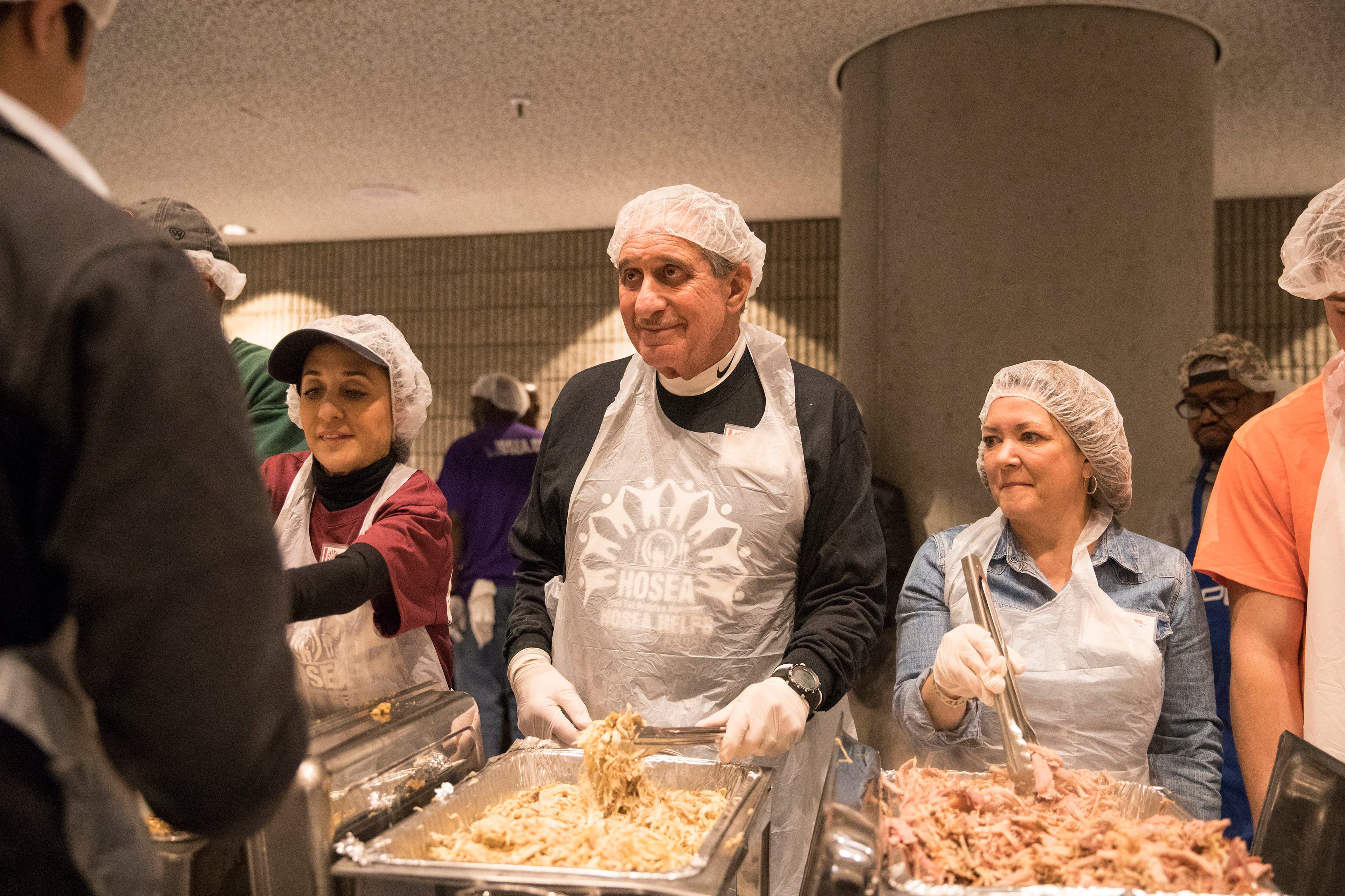 Atlanta Falcons owner Arthur Blank, center, and his wife Angela Macuga, serve food during the annual Hosea Helps Thanksgiving dinner at the Georgia World Congress Center, Thursday, November 23. ALYSSA POINTER/ALYSSA.POINTER@AJC.COM