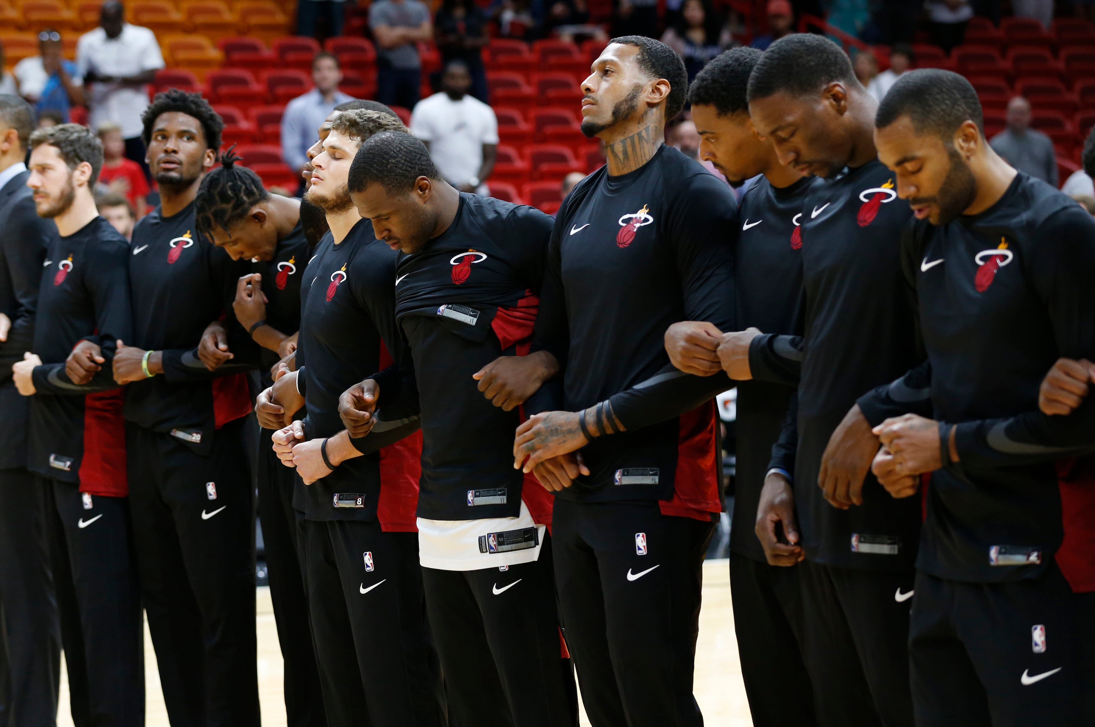 Members of the Miami Heat link arms during the National Anthem before the start of a game against the Hawks on Sunday, Oct. 1.