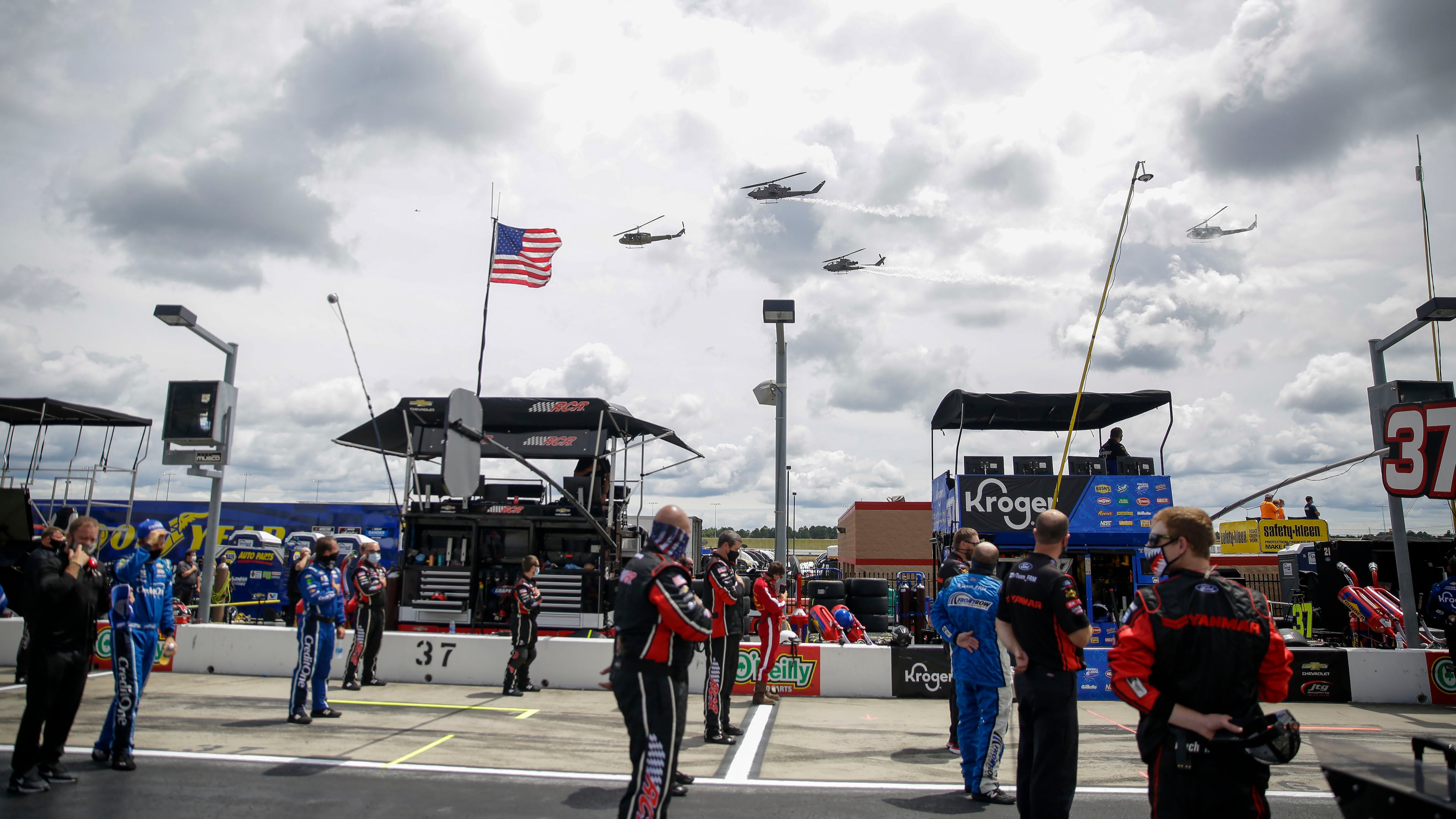 NASCAR drivers and crew members watch a military flyover before the Folds of Honor QuikTrip 500 Sunday, June 7, 2020, at Atlanta Motor Speedway in Hampton, Ga.