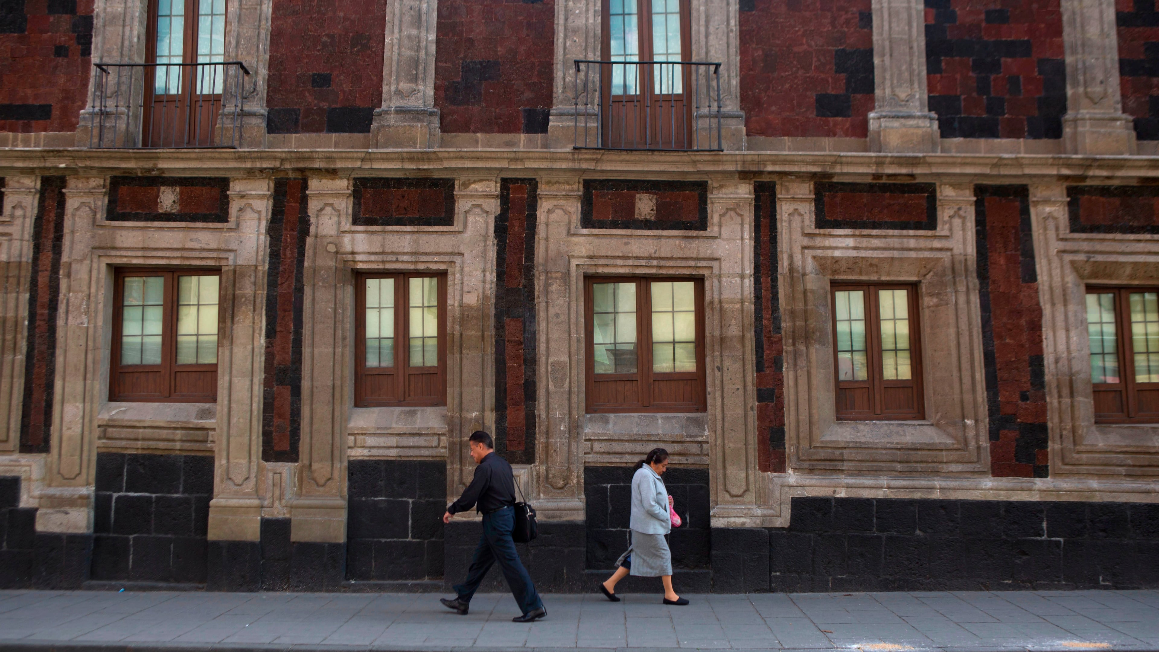 FILE - Pedestrians walk past a slightly tilted historic building in downtown Mexico City, June 15, 2016. The city was built on a drained lake bed and many buildings are noticeably tilted, from sinking unevenly into the soft earth over decades or centuries. (AP Photo/Rebecca Blackwell, File)