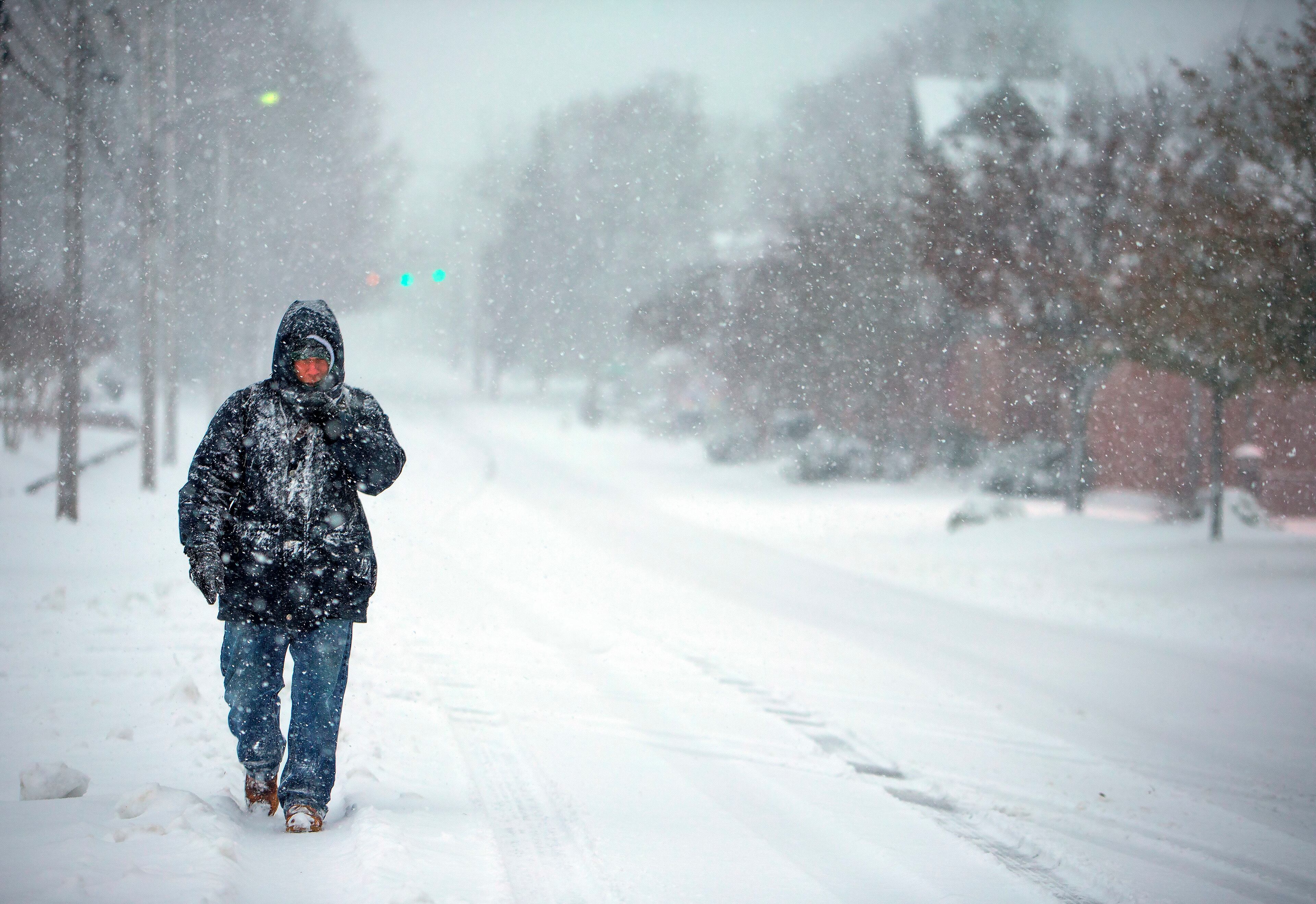 Daniel Travis walks down State Street as snow falls over Lexington, NC on Sunday, December 9, 2018. "I love snow so I got up early at 5:45 so I could be out in it," Travis said. (H. Scott Hoffman/News & Record via AP)