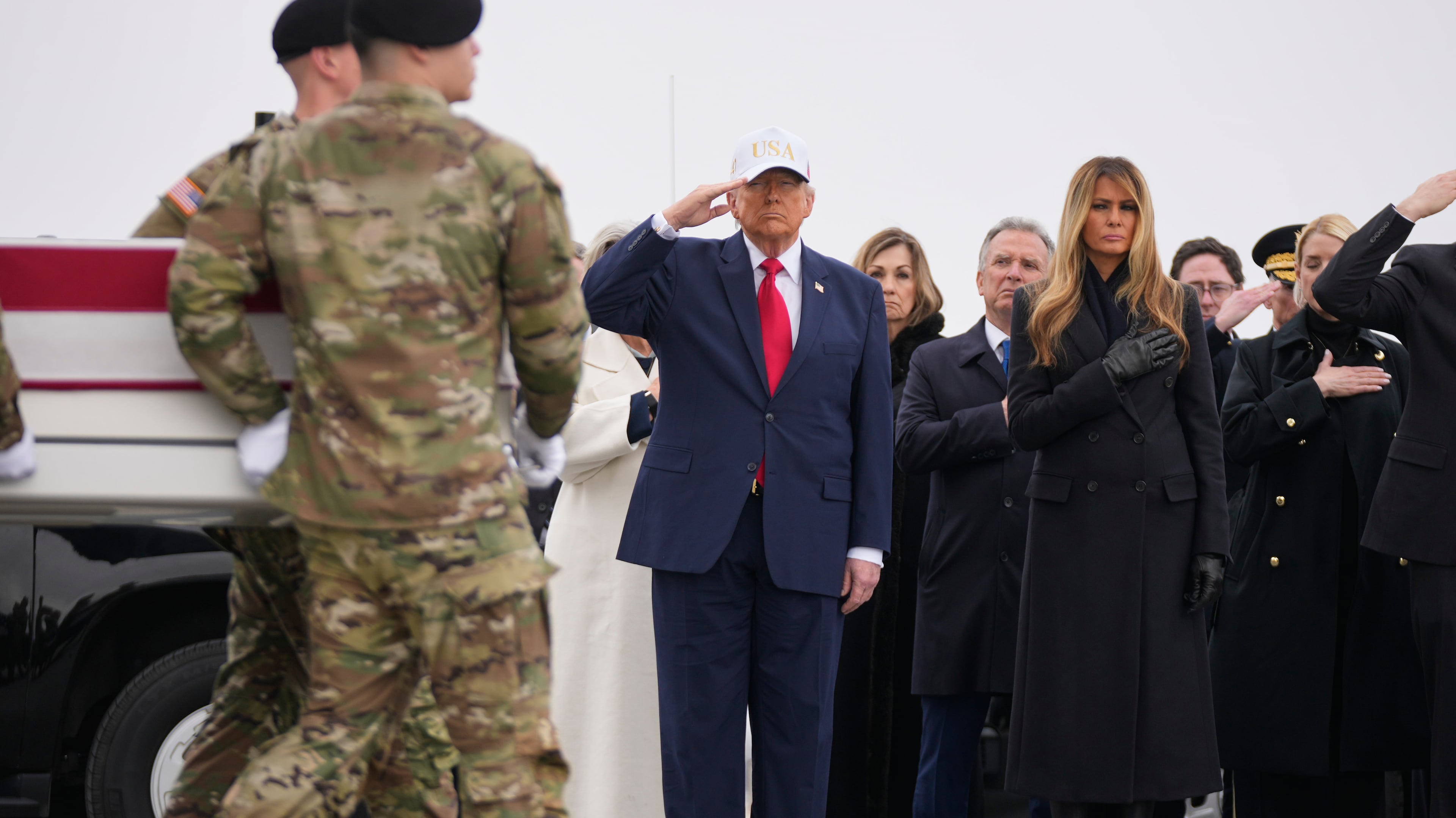 An Army carry team moves a flag-draped transfer case with the remains of U.S. Army Reserve soldier Sgt. 1st Class Nicole Amor, of White Bear Lake, Minn., who was killed in a drone strike at a command center in Kuwait after the U.S. and Israel launched its military campaign against Iran, past President Donald Trump and first lady Melania Trump during a casualty return, Saturday, March 7, 2026, at Dover Air Force Base, Del. (AP Photo/Mark Schiefelbein)