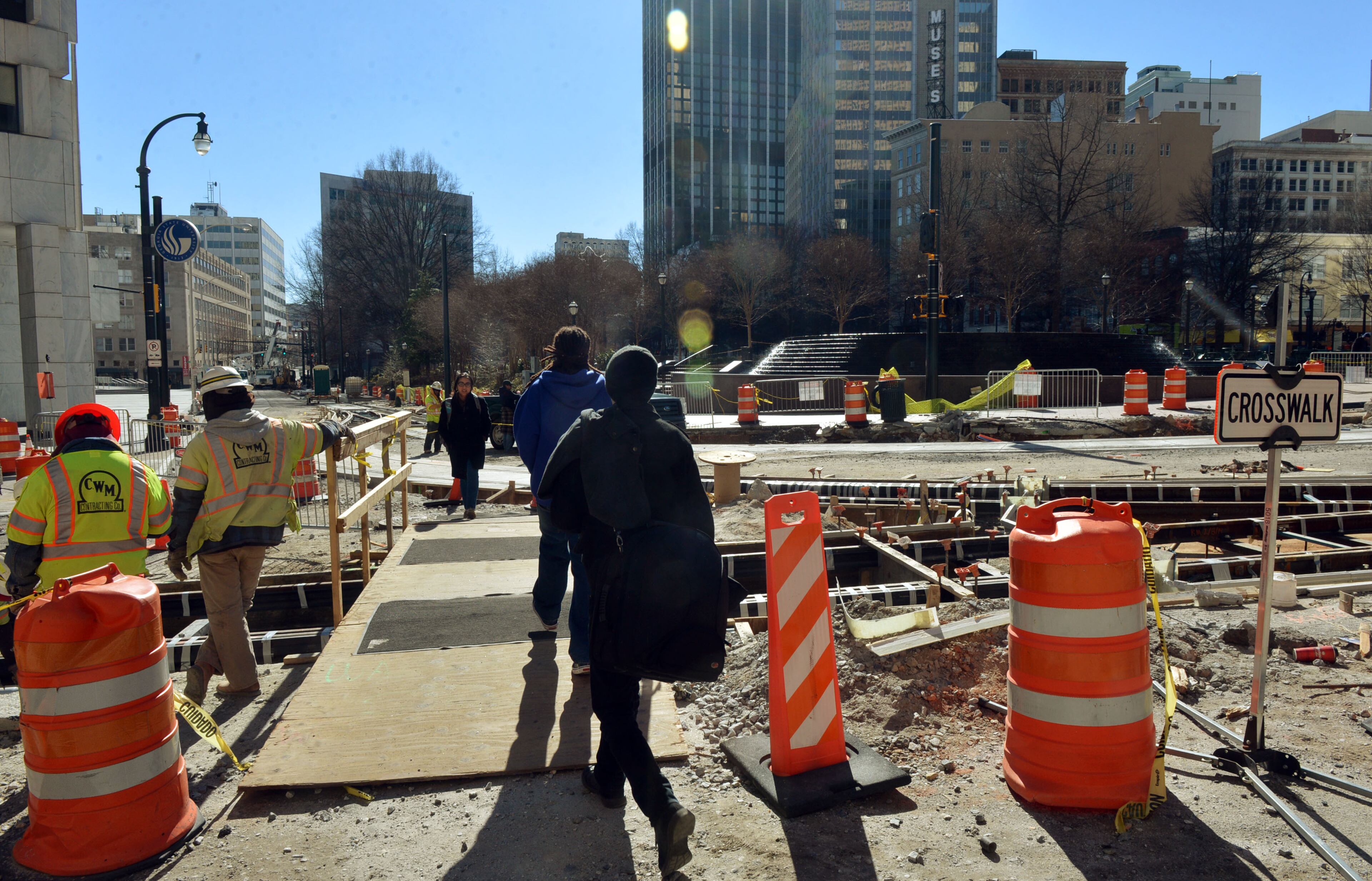 Pedestrians cross a temporary bridge across trackwork still under construction along Auburn Ave near Woodruff Park. Photos along the route of the downtown streetcar, shot Thursday, February 27, 2014. Less than three months from the planned launch of the new Atlanta Streetcar service, the city has yet to decide who will operate and maintain it.
