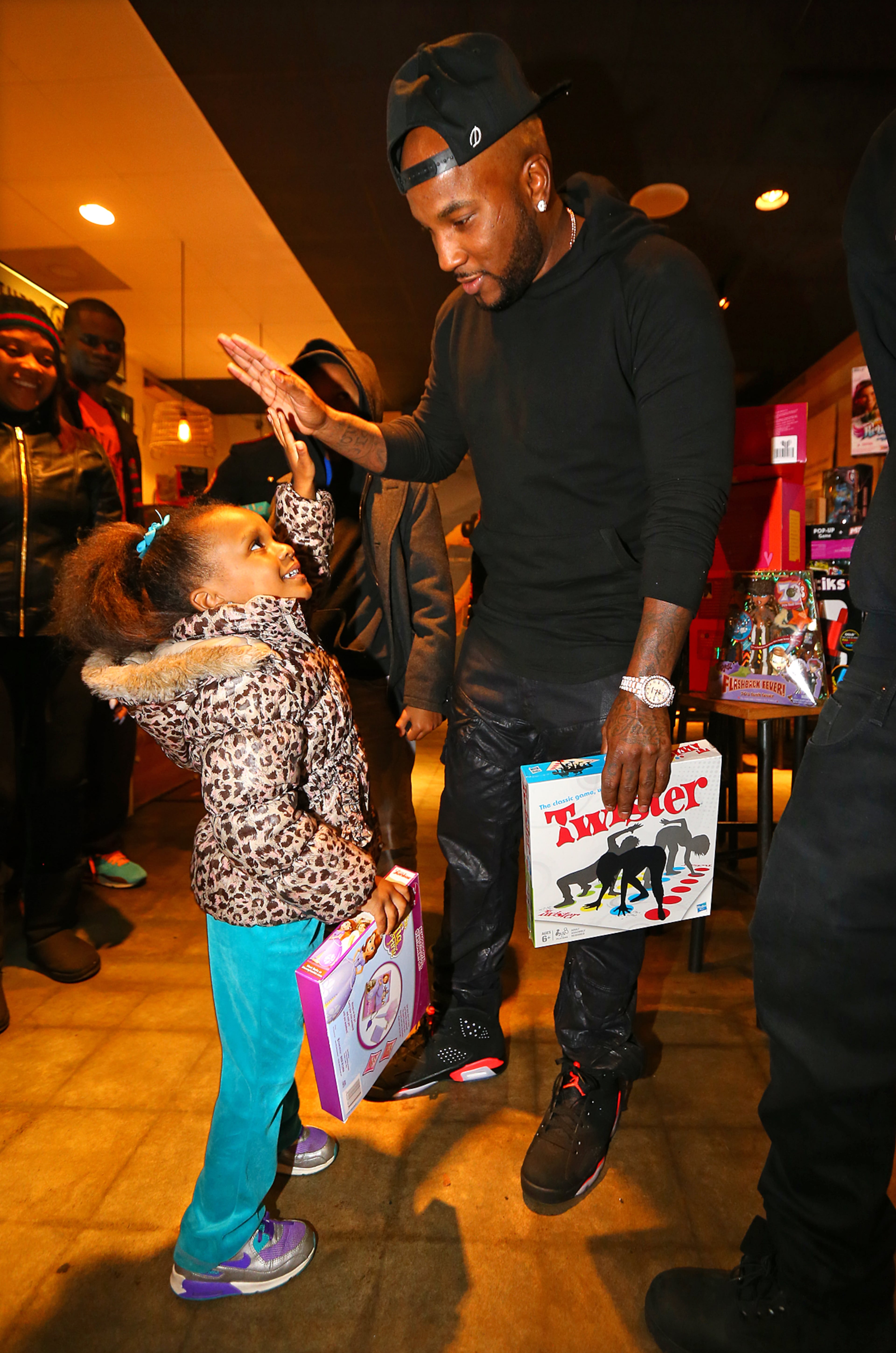 Khloe Smith, 4, gives Jeezy a high five after he hands her a toy playing Santa to around 200 needy inner city kids from Macon, Hawkinsville, and Atlanta for Christmas on Monday, Dec. 22, 2014, in Atlanta. The children were treated to a private screening of the movie Annie, followed by food and toys given out by "Santa Jeezy" at Gio's. Curtis Compton / ccompton@ajc.com