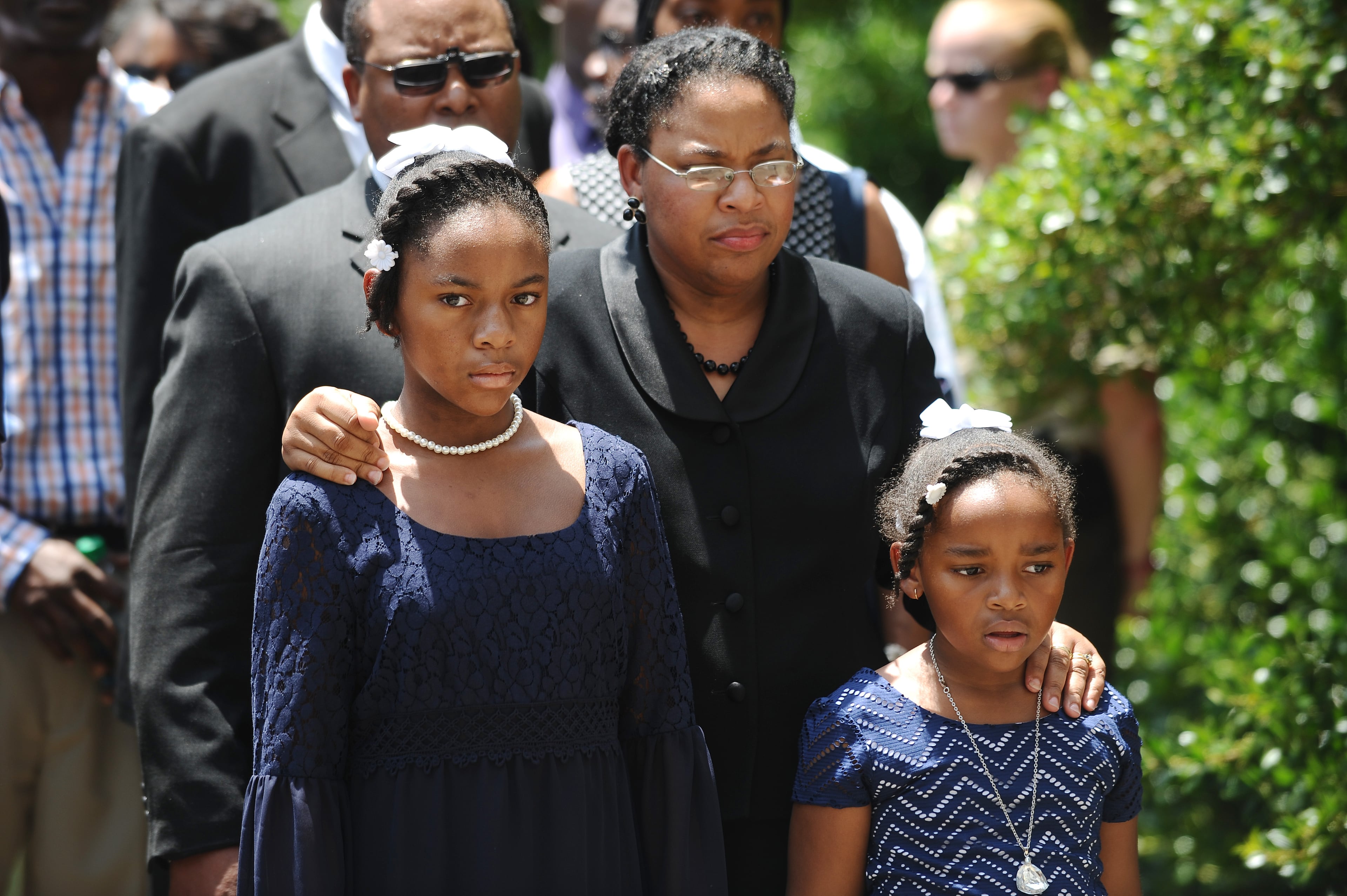 Sen. Clementa Pinckney's wife Jennifer Pinckney, center, and her daughters, Eliana, left, and Malana, right, follow his casket into the South Carolina Statehouse, Wednesday, June 24, 2015, in Columbia, S.C. Pinckney's open coffin was being put on display under the dome where he served the state for nearly 20 years. Pinckney was one of those killed in a mass shooting at the Emanuel AME Church in Charleston. (AP Photo/Rainier Ehrhardt)