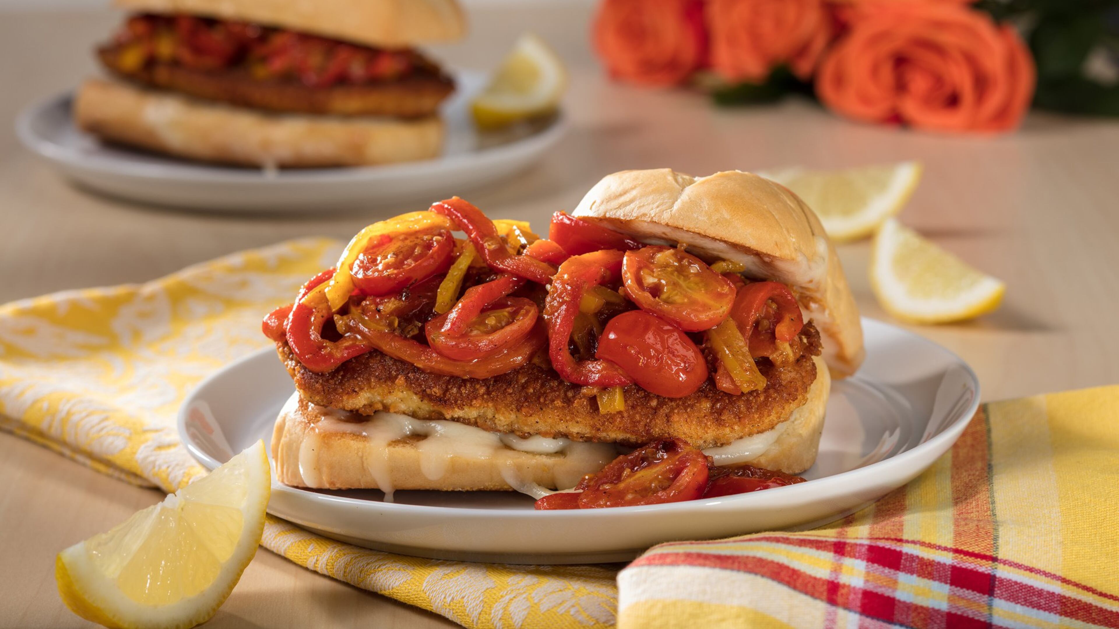A saute of tomatoes, yellow bell peppers and cherry peppers bolsters the crisp breaded cutlet in this chicken Parmesan sandwich. (Zbigniew Bzdak/Chicago Tribune/TNS)