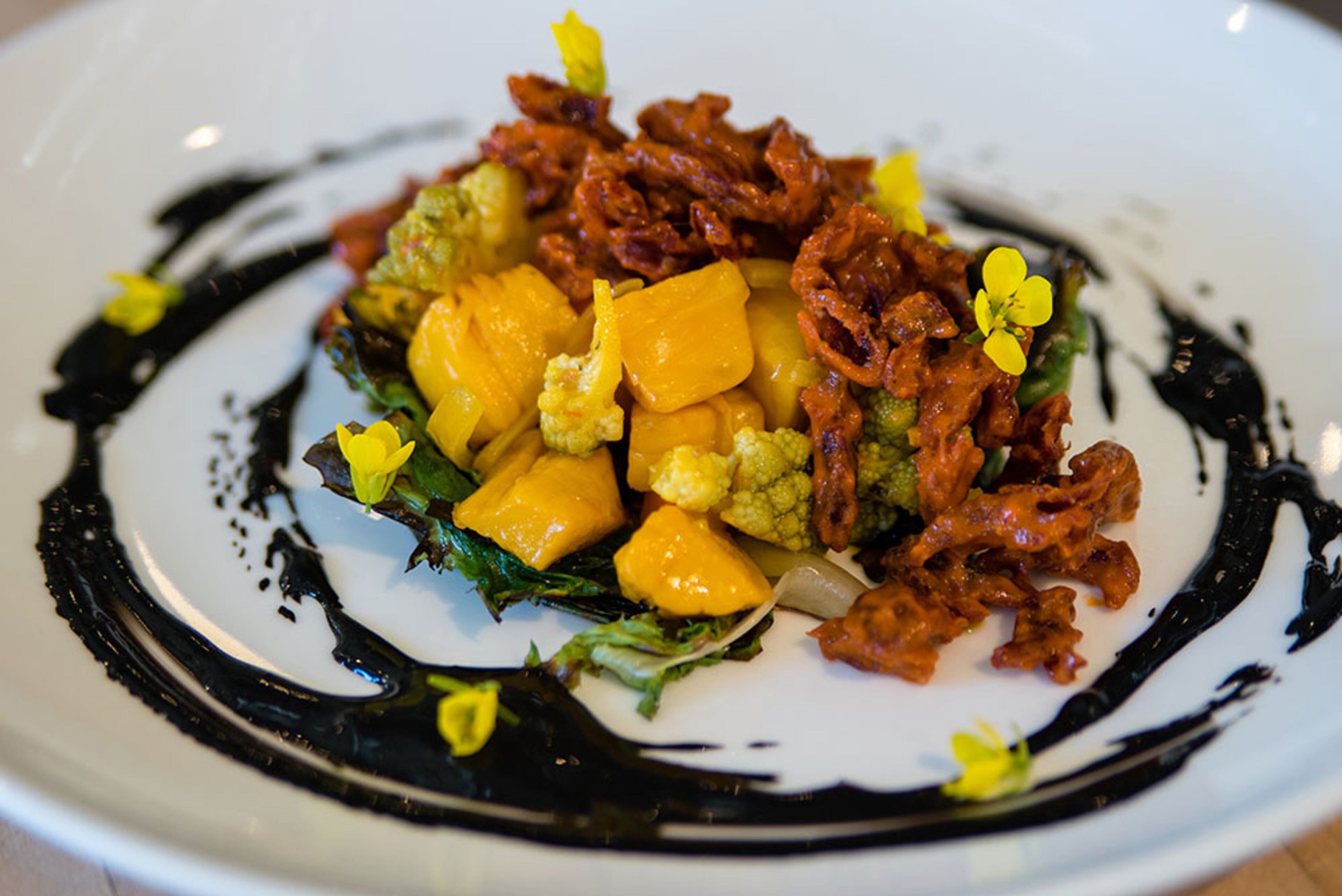 Scallop escabeche with pork carnitas, patatas bravas, cauliflower and squid ink at Gunshow.