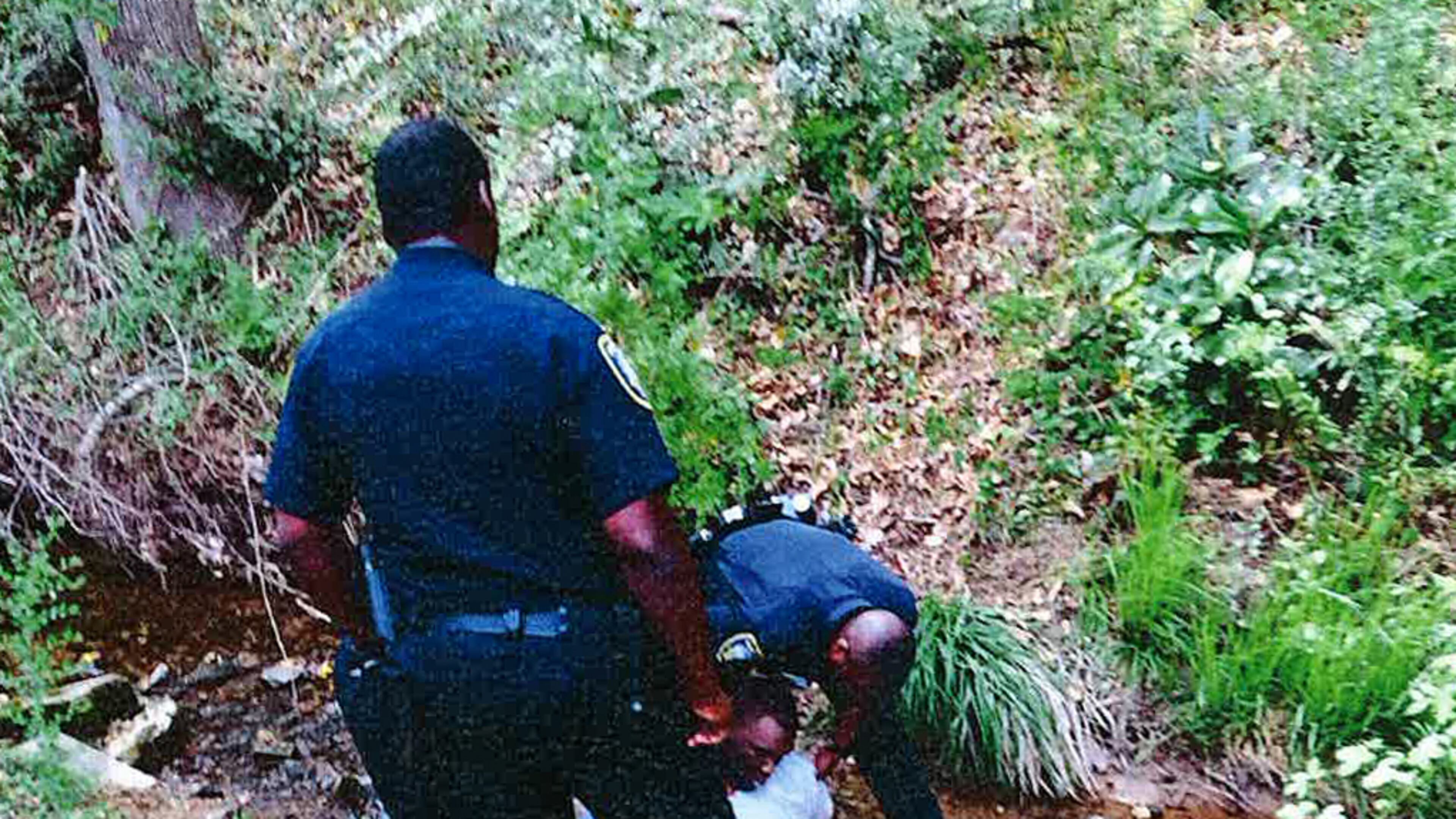 A witness photographed former East Point police officers, Cpl. Howard Weems and Sgt. Marcus Eberhart, as they tried to get Gregory Lewis Towns Jr. to stand after they chased him almost a mile. (HANDOUT photo provided by Chris Stewart)