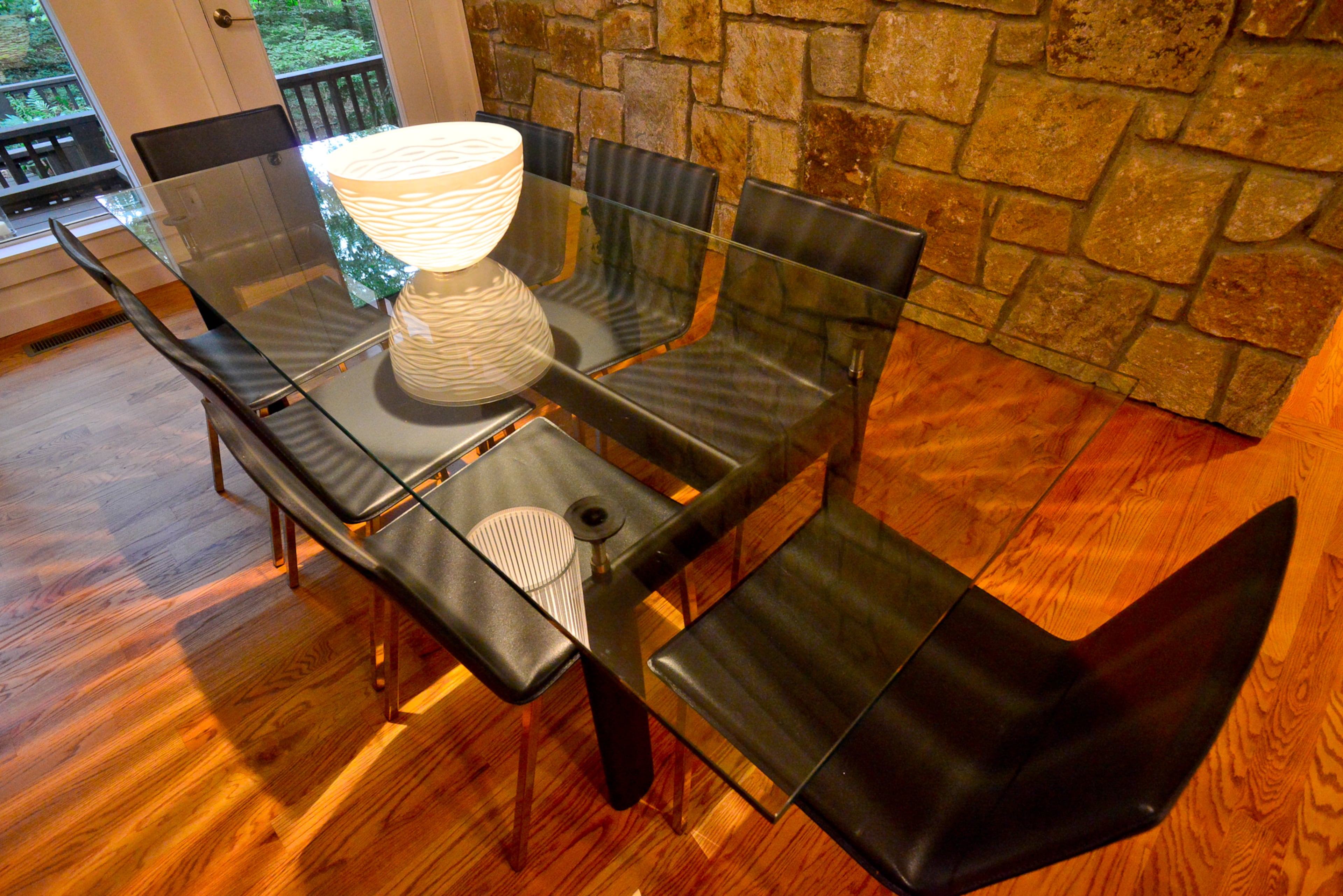 A dining room chandelier from Room & Board illuminates glass dining room table from allmodern.com. Charcoal dining room chairs are from CB2 are clean-lined selections.