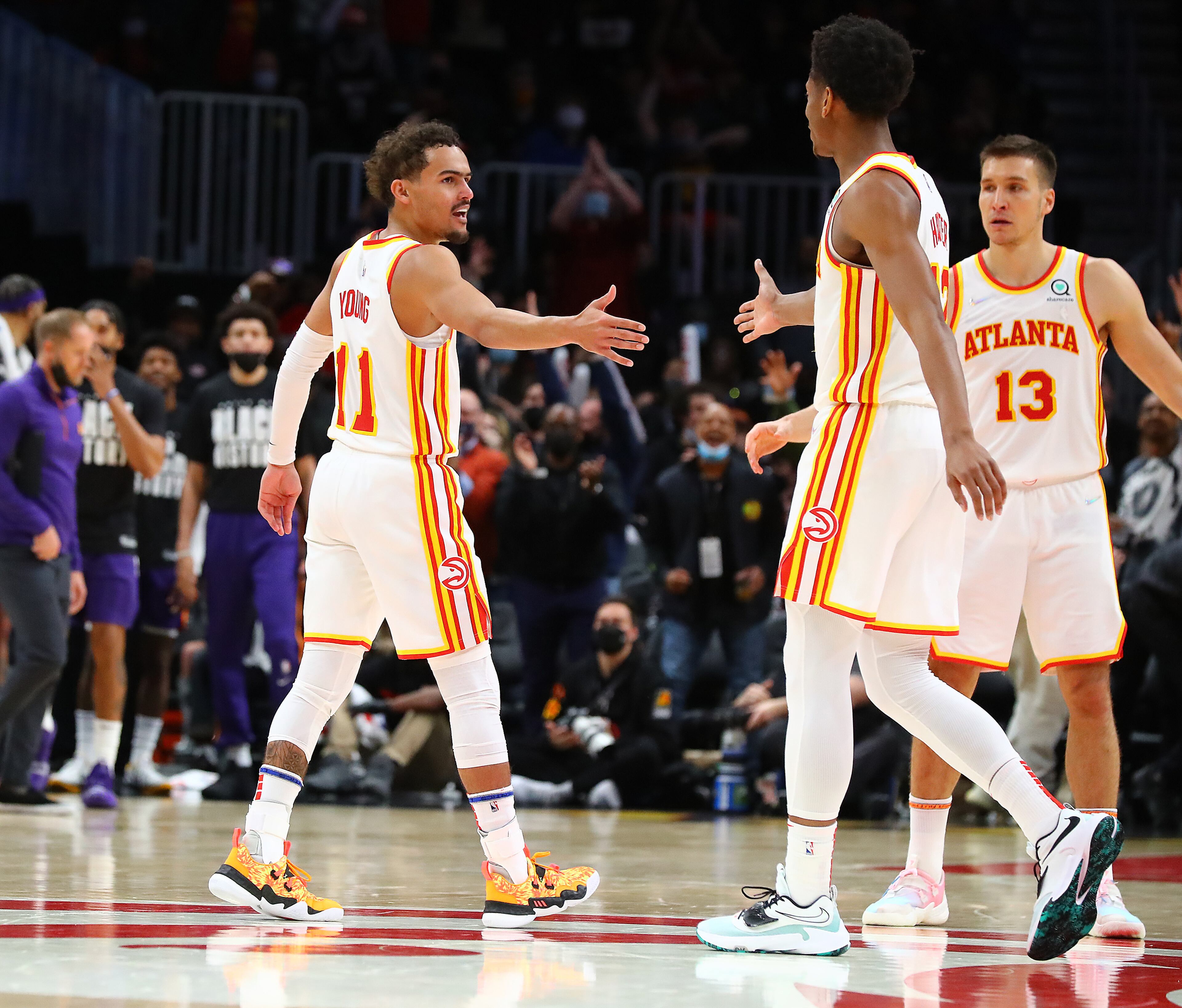 Hawks guard Trae Young gets five from De'Andre Hunter and Bogdan Bogdanovic after beating the Phoenix Suns 124-115 in a NBA basketball game on Thursday, Feb. 3, 2022, in Atlanta. “Curtis Compton / Curtis.Compton@ajc.com”`