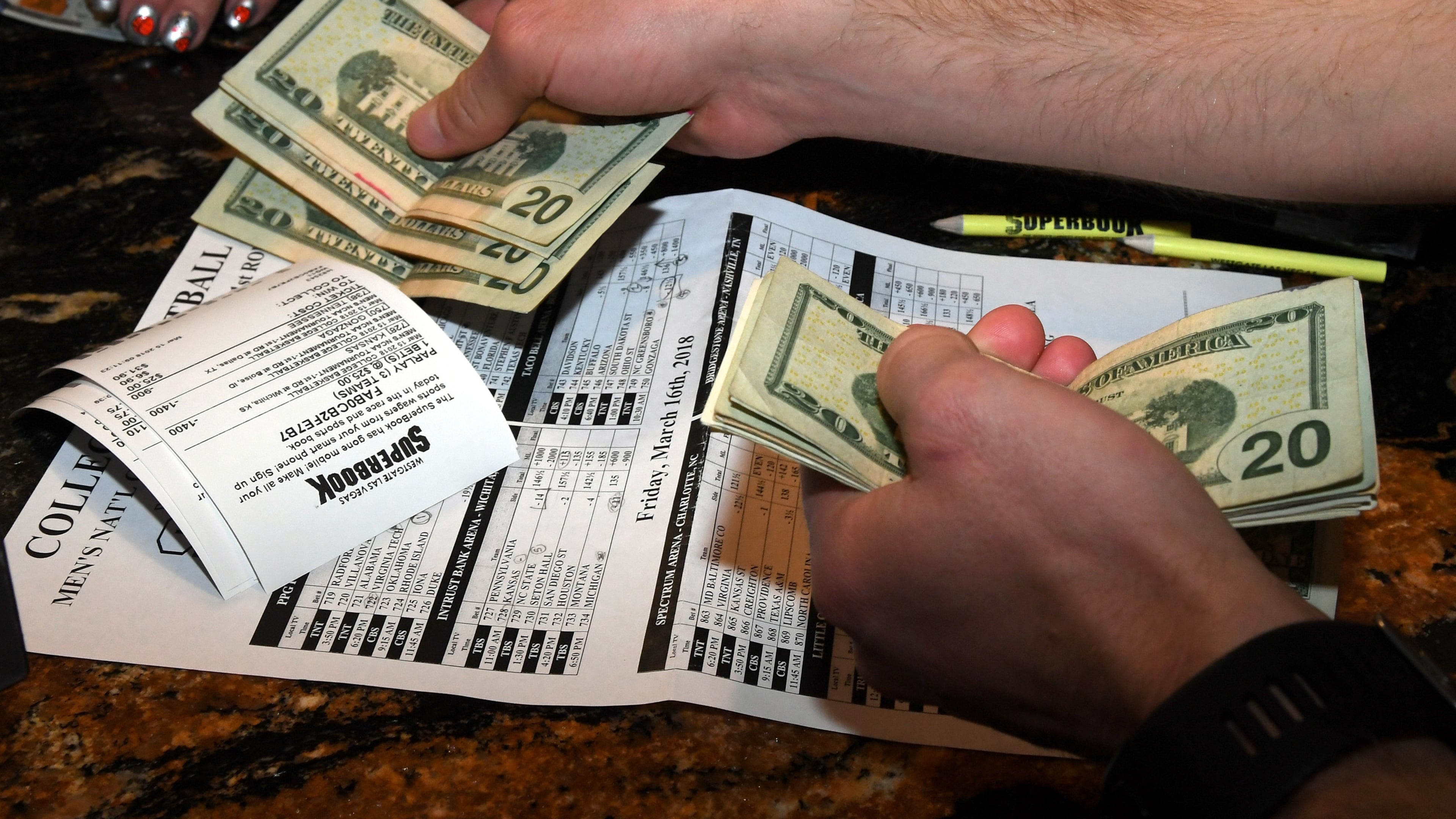 A gambler makes bets during a viewing party for the NCAA men's college basketball tournament inside the 25,000-square-foot Race & Sports SuperBook at the Westgate Las Vegas Resort & Casino. (Ethan Miller/TNS)