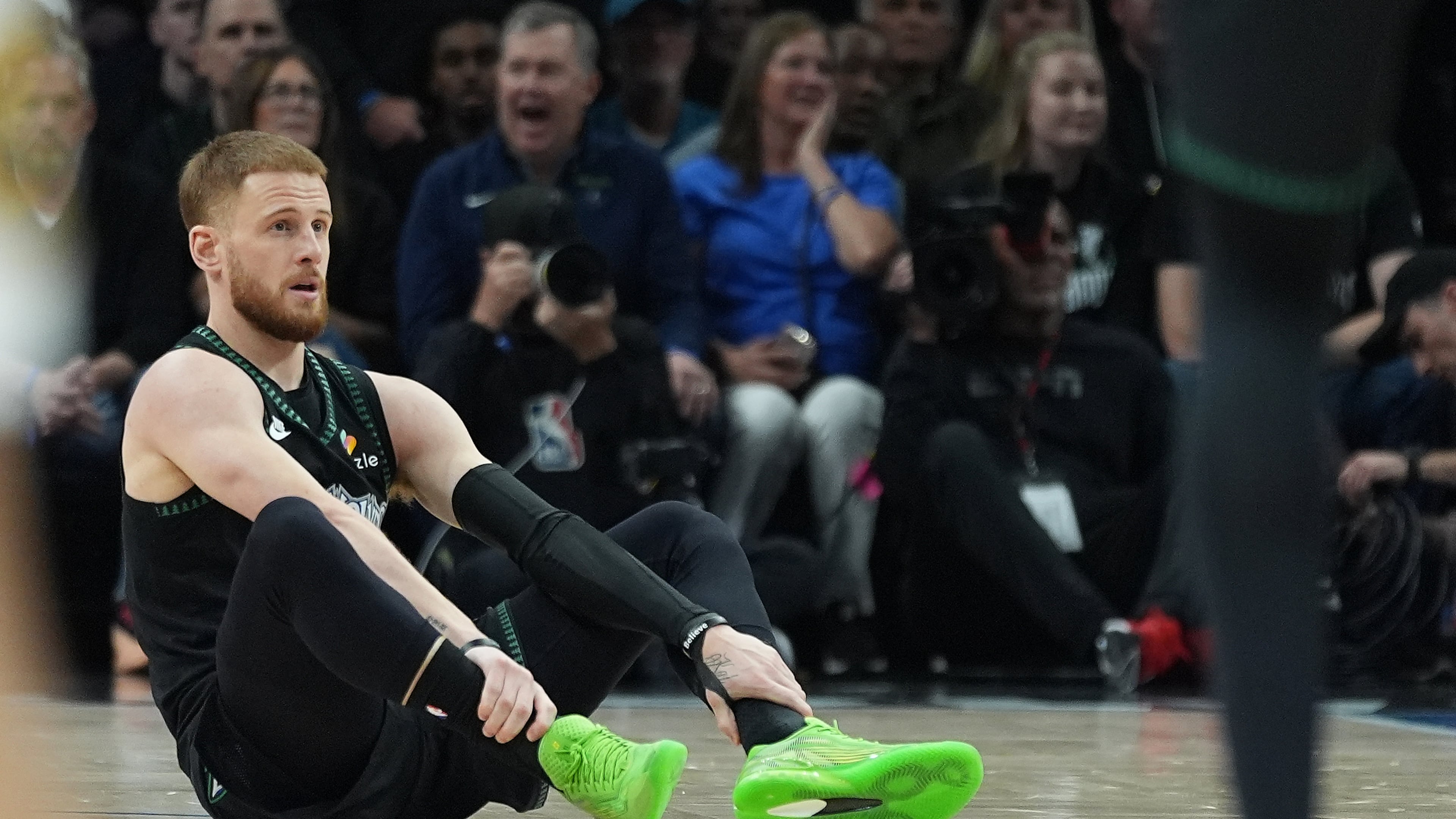 Minnesota Timberwolves guard Donte DiVincenzo (0) sits on the court after sustaining an injury during the first half of Game 4 of a first-round NBA basketball playoff series against the Denver Nuggets, Saturday, April 25, 2026, in Minneapolis. (AP Photo/Abbie Parr)