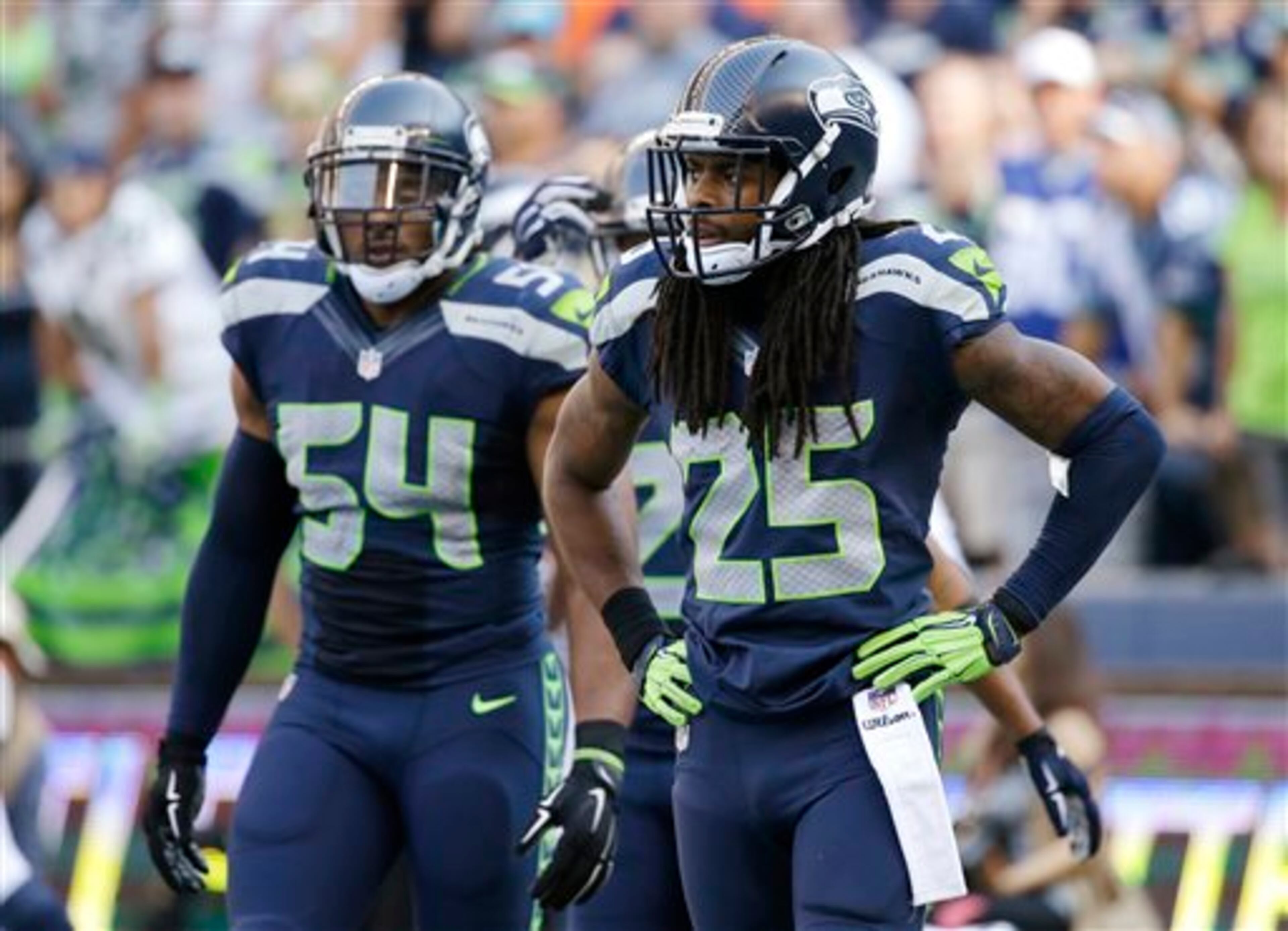 Seattle Seahawks cornerback Richard Sherman (25) and Bobby Wagner (54) react after the Denver Broncos tied the NFL football game late in the second half, Sunday, Sept. 21, 2014, in Seattle. The Seahawks won 26-20 in overtime. (AP Photo/Elaine Thompson)