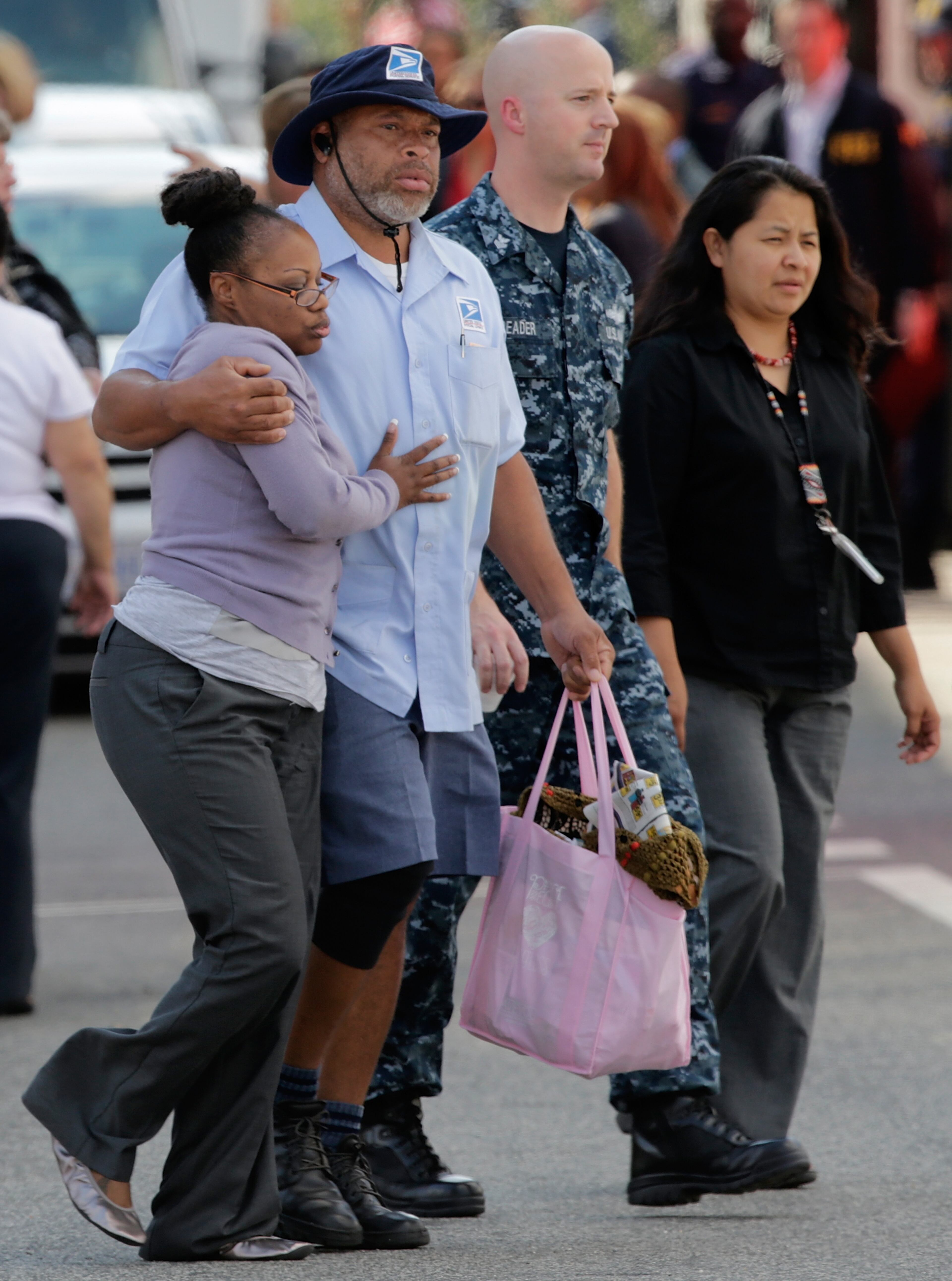 After a bus dropped off employees recently released from the Navy Yard complex, a couple walks away from a gathering point for families that was set up inside Nationals Park in the wake of the Navy Yard shooting Sept. 16, 2013, in Washington, D.C.