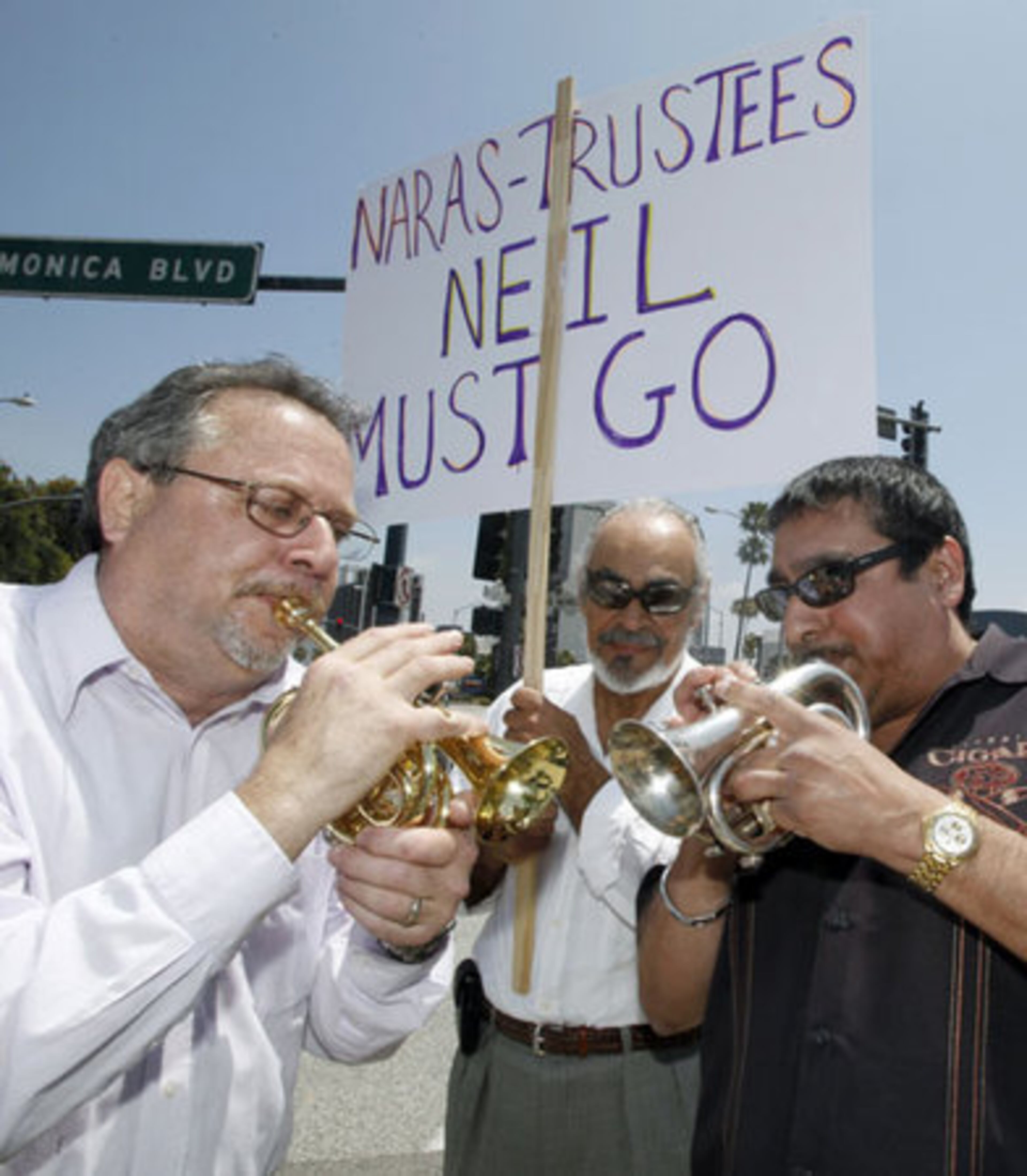 Ismael Carlo, center, listens as Gary Eisenberg, left, and Latin jazz bandleader Bob Desena play music during a demonstration demanding the restoration of some categories cut from the Grammy Awards.