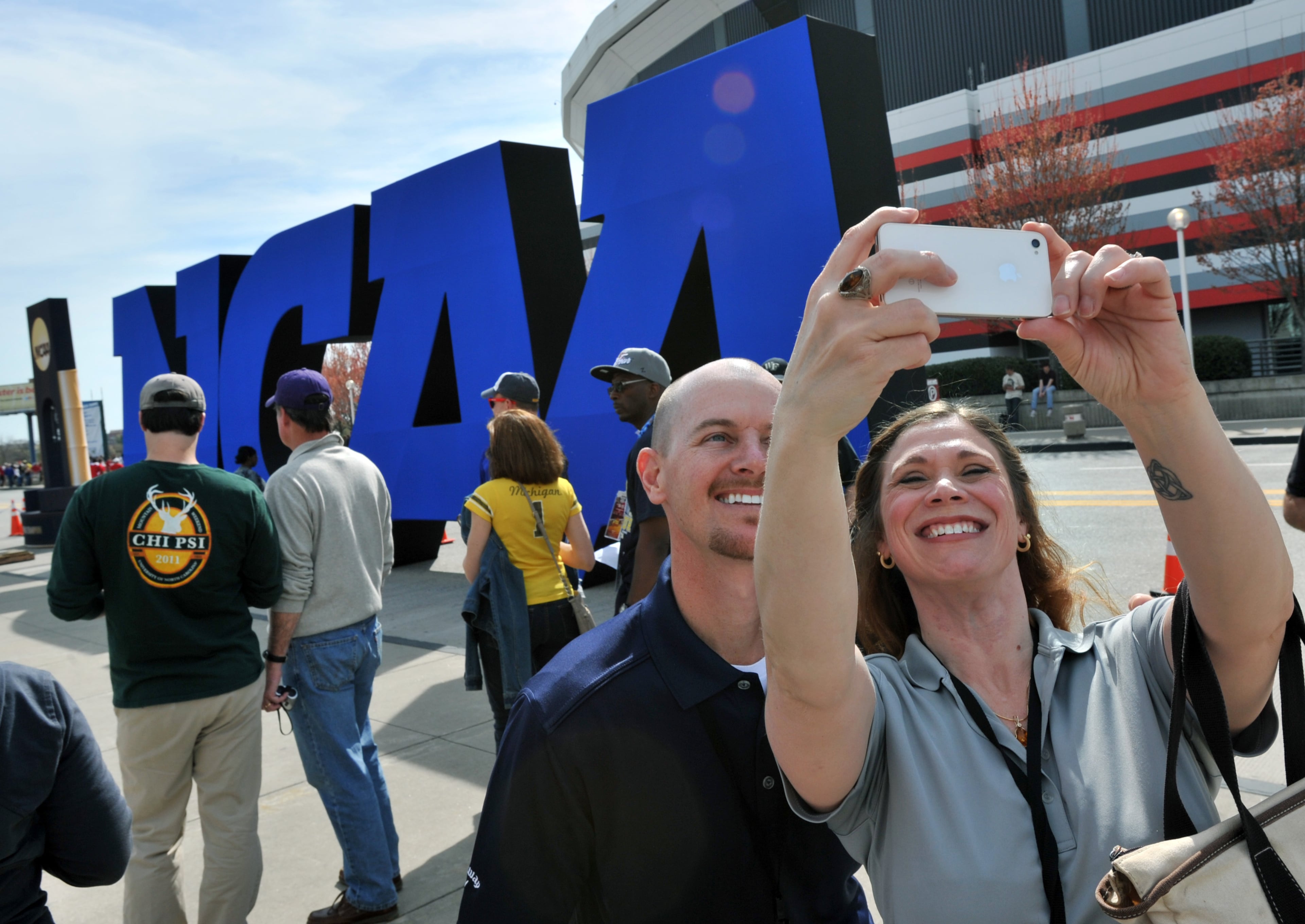 April 6, 2013-ATLANTA: Vanessa Zoeller (right), of Lawrenceville, and Todd Goldem, of Clermont, Fla., take their picture with a big NCAA sign outside the Georgia Dorm before NCAA Final Four semi-finals on Saturday, April 6, 2013.
