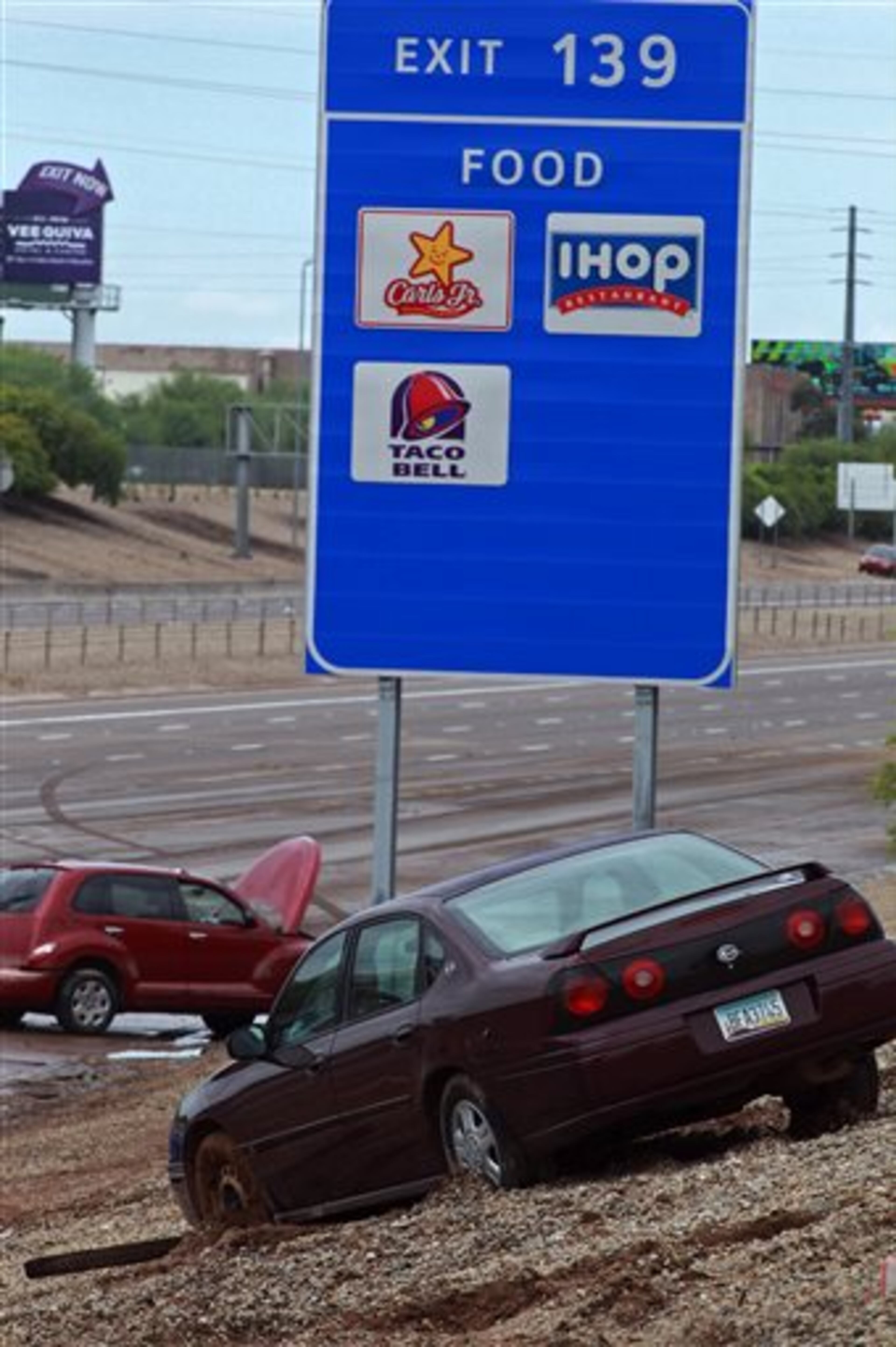 Vehicles remain along a section of westbound Interstate 10 following heavy rains and flooding that left motorists stranded during their morning commute on Monday, Sept. 8, 2014 in Phoenix. Monday's record breaking rainfall flooded several Phoenix-area freeways and local streets forcing closures with some areas reporting up to five inches of rain. (AP Photo/Ralph Freso)