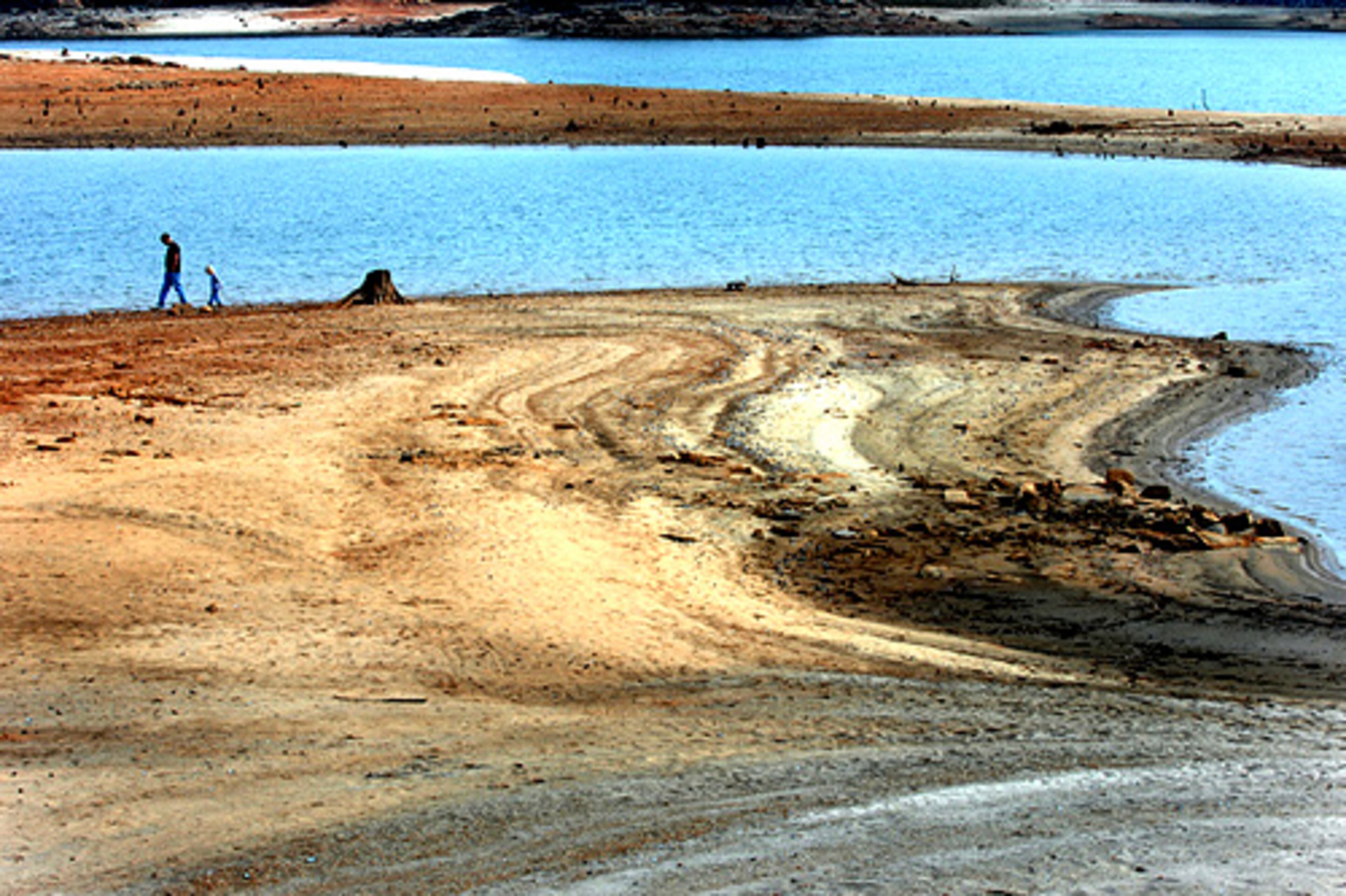 James Dellana of Braselton and his daughter, Ariel, 3, look for shells at Van Pugh Park (west of the Aqualand Marina), where the shore is more than 100 yards from the park's swimming area.