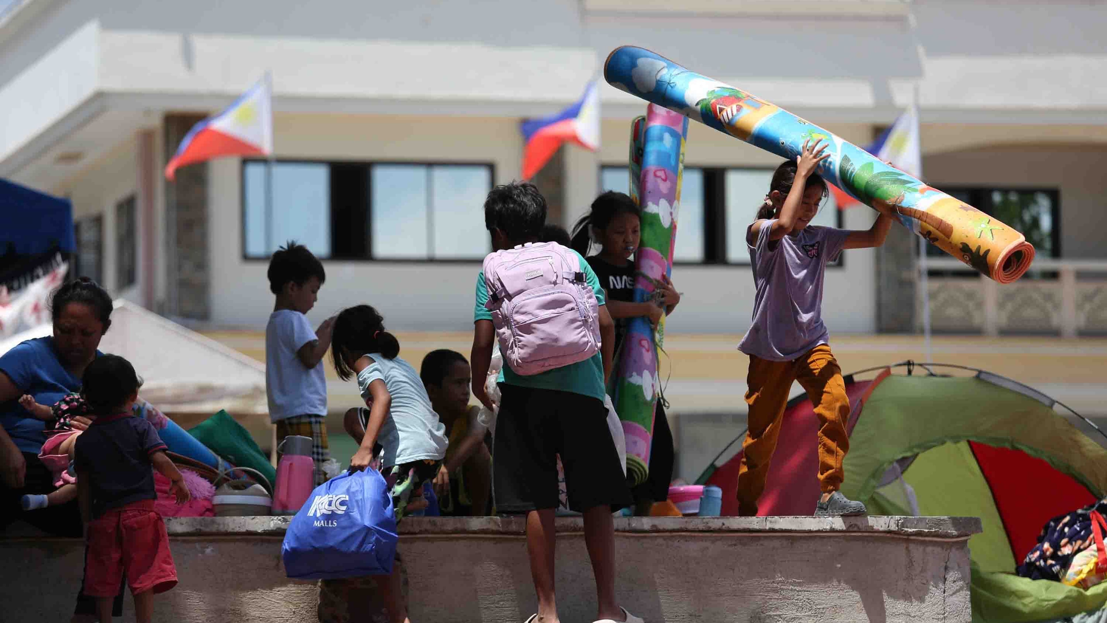 Residents take shelter in a field at a municipal hall in Sarangani province, Philippines, Wednesday, June 10, 2026. (AP Photo/Basilio Sepe)