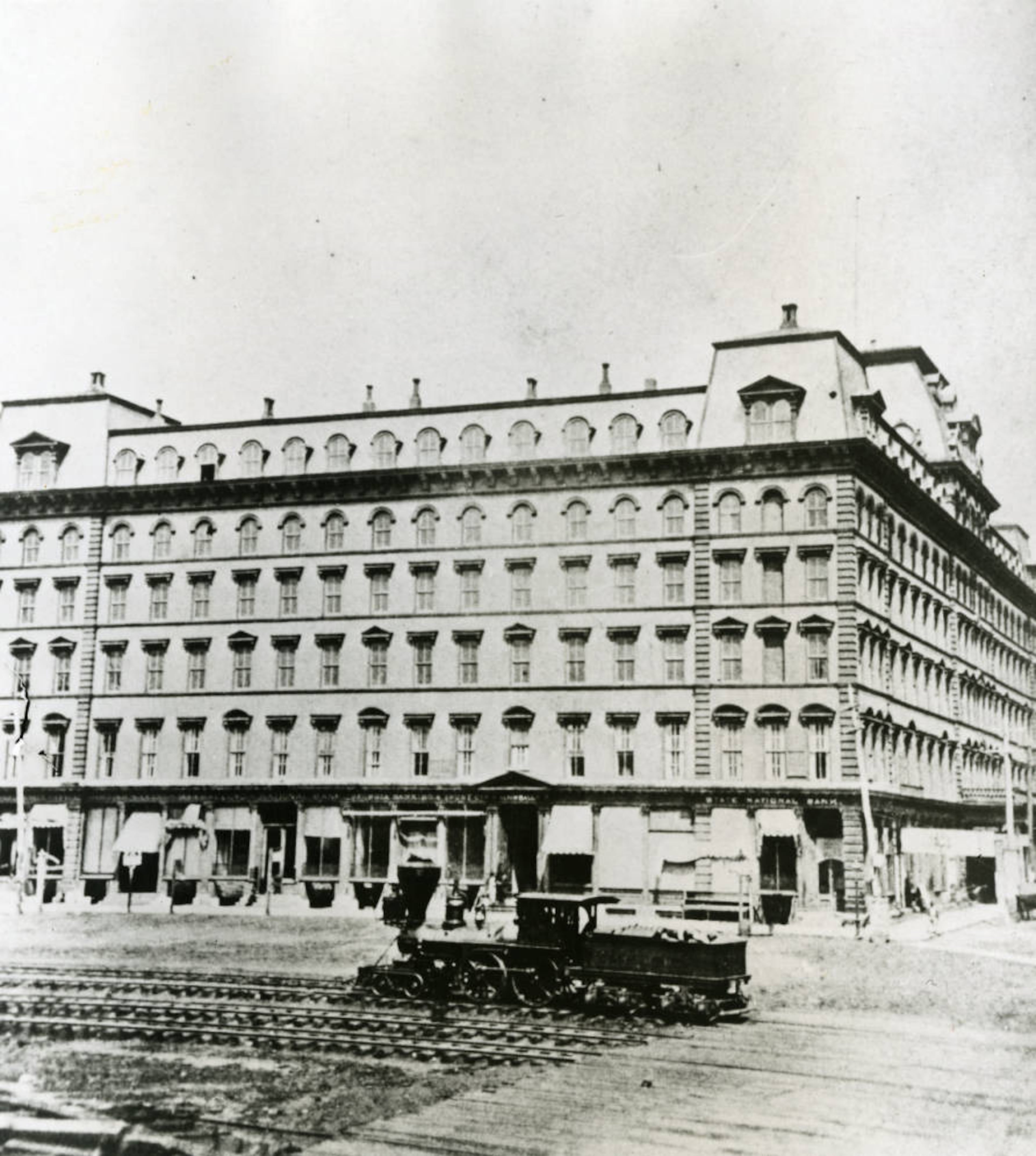 The south facade of the first Kimball House in 1875 shows railroad tracks and a wood-burning locomotive engine. It was the home of several banks as well as a hotel. (AJC Archive at GSU Library)