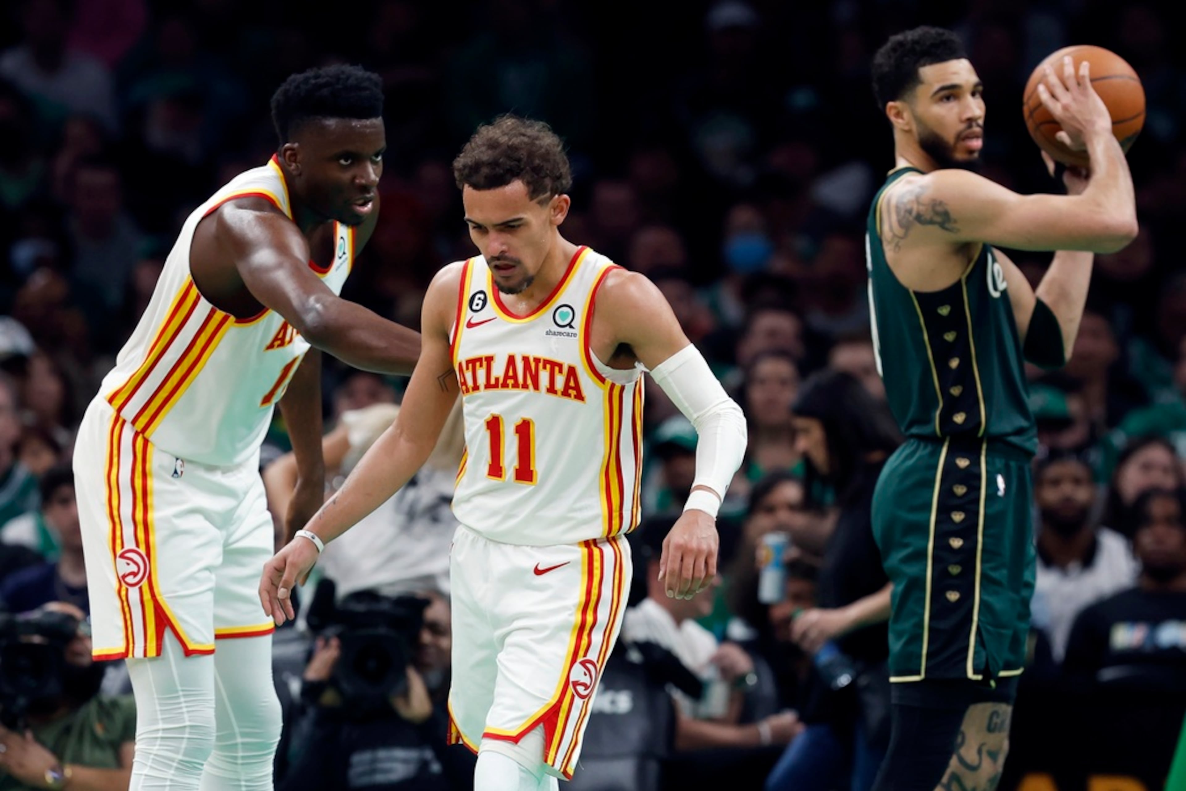Atlanta Hawks' Clint Capela, left, reaches out to Trae Young (11) beside Boston Celtics' Jayson Tatum, right, in the second half during Game 1 in the first round of the NBA basketball playoffs, Saturday, April 15, 2023, in Boston. (AP Photo/Michael Dwyer)
